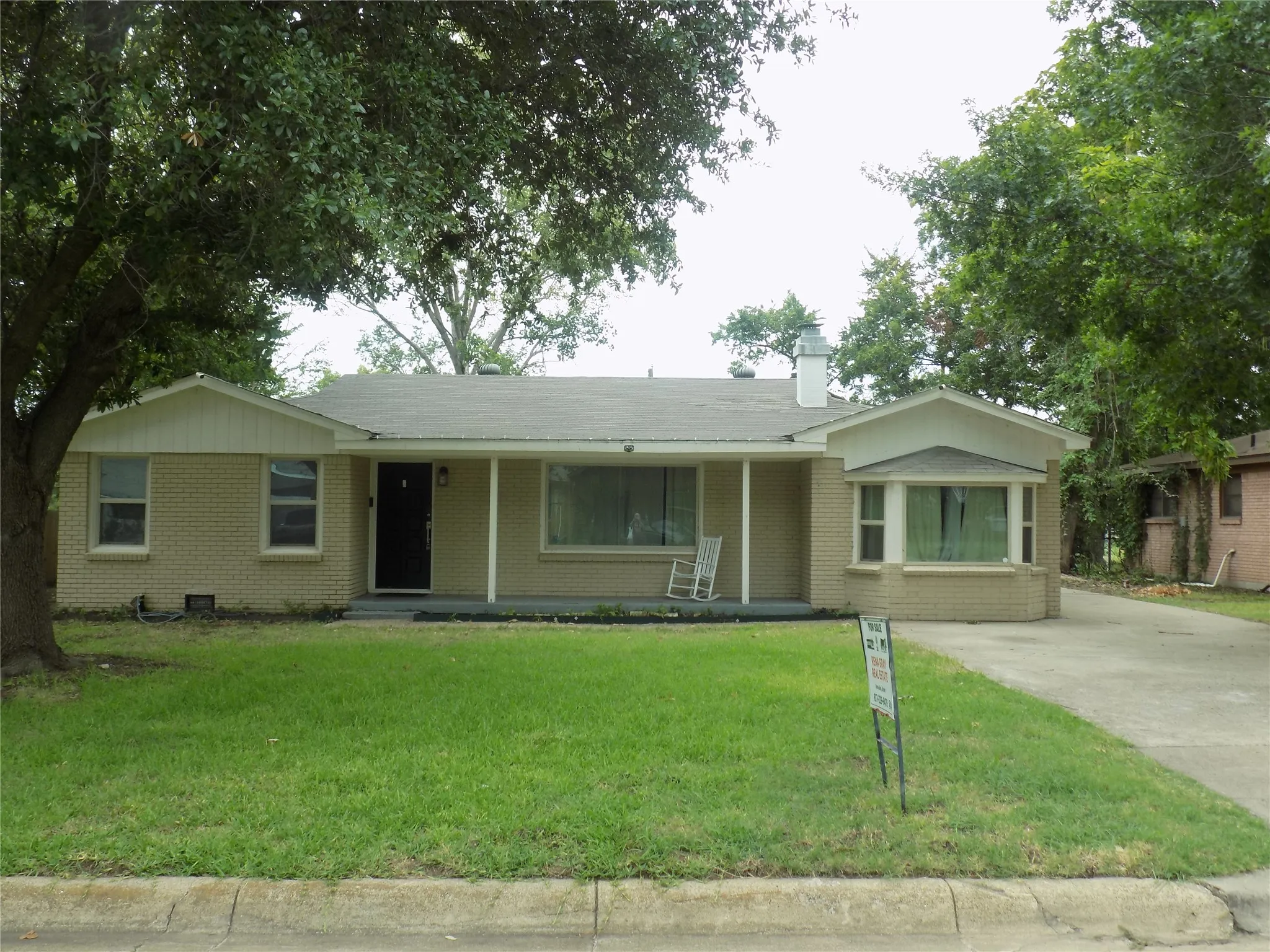 Notice large, covered porch with drive-way to garage and back yard.