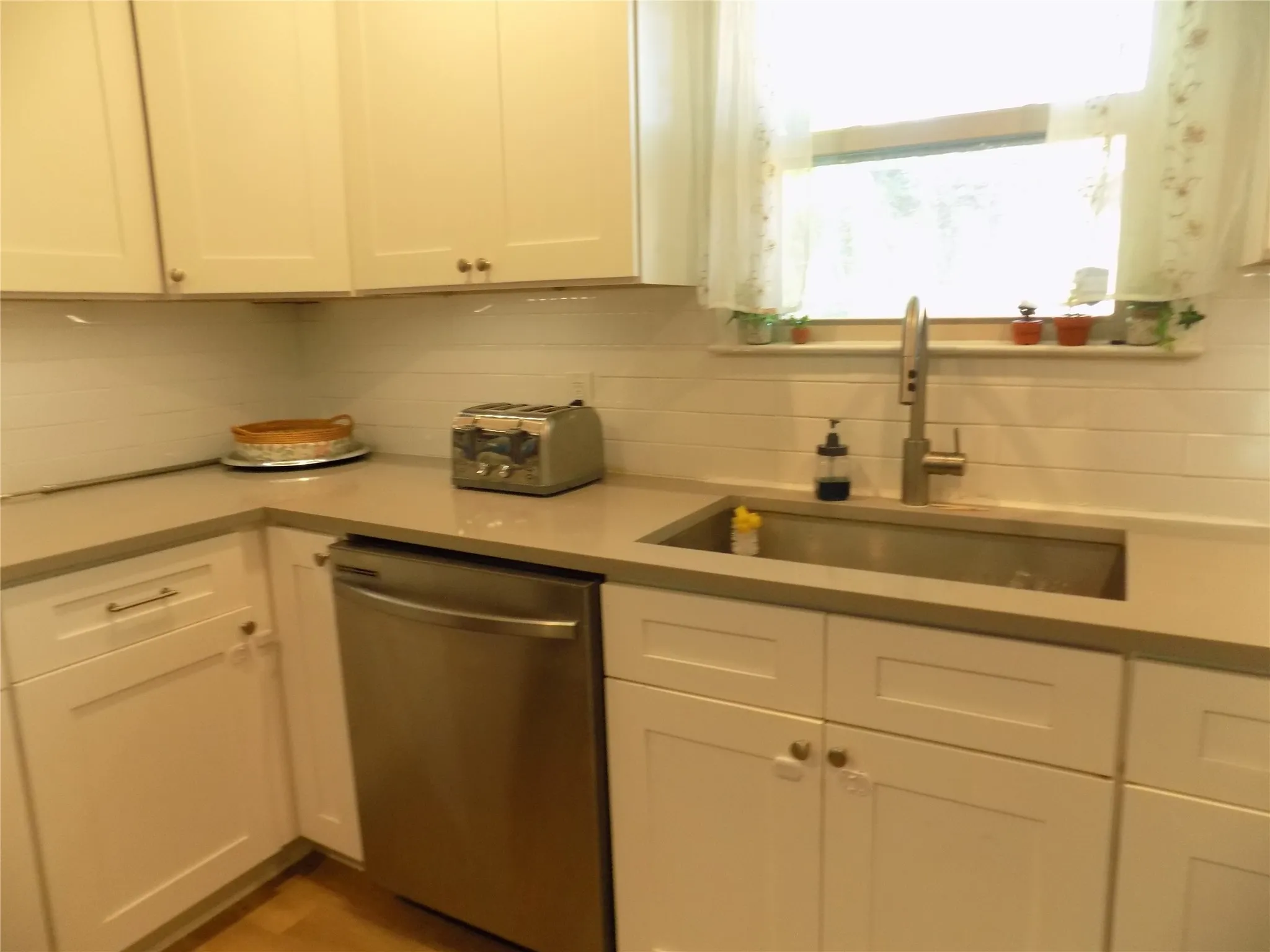Large under cabinet stainless steel farm sink, stainless steel dishwasher.