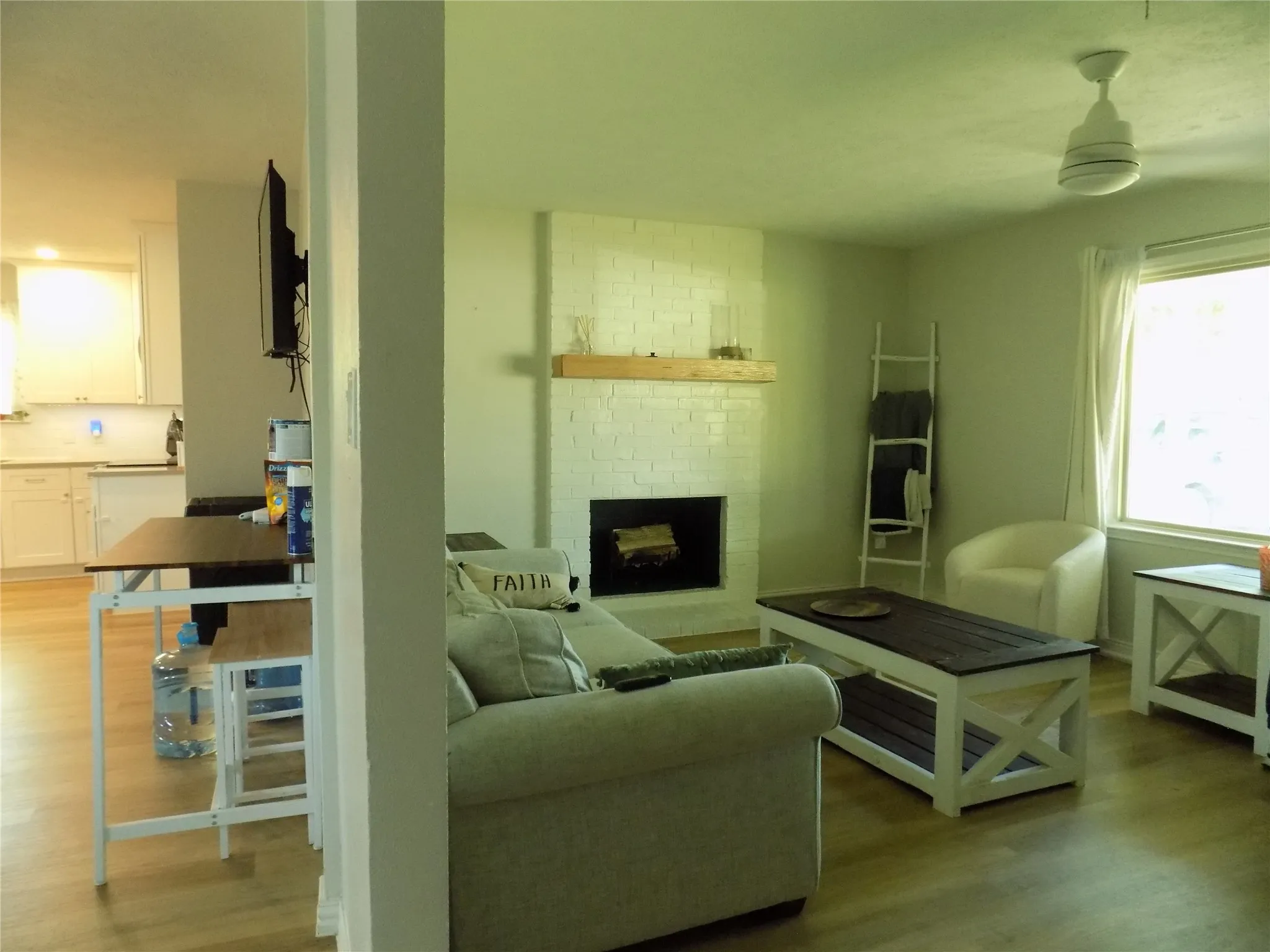 Fireplace with mantle and picture window, spacious room.