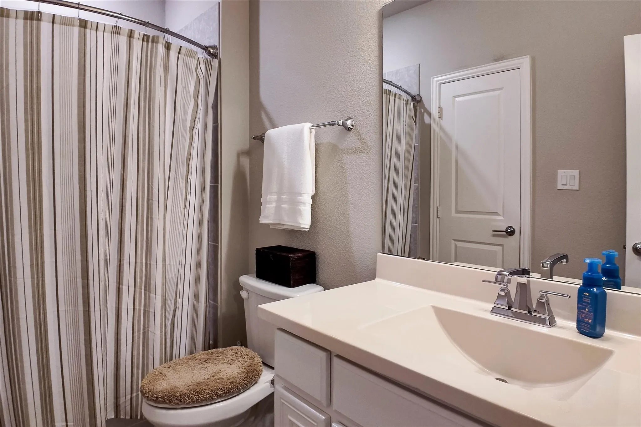 Bathroom featuring a vanity with an integrated sink, polished chrome faucet, and a large wall-mounted mirror