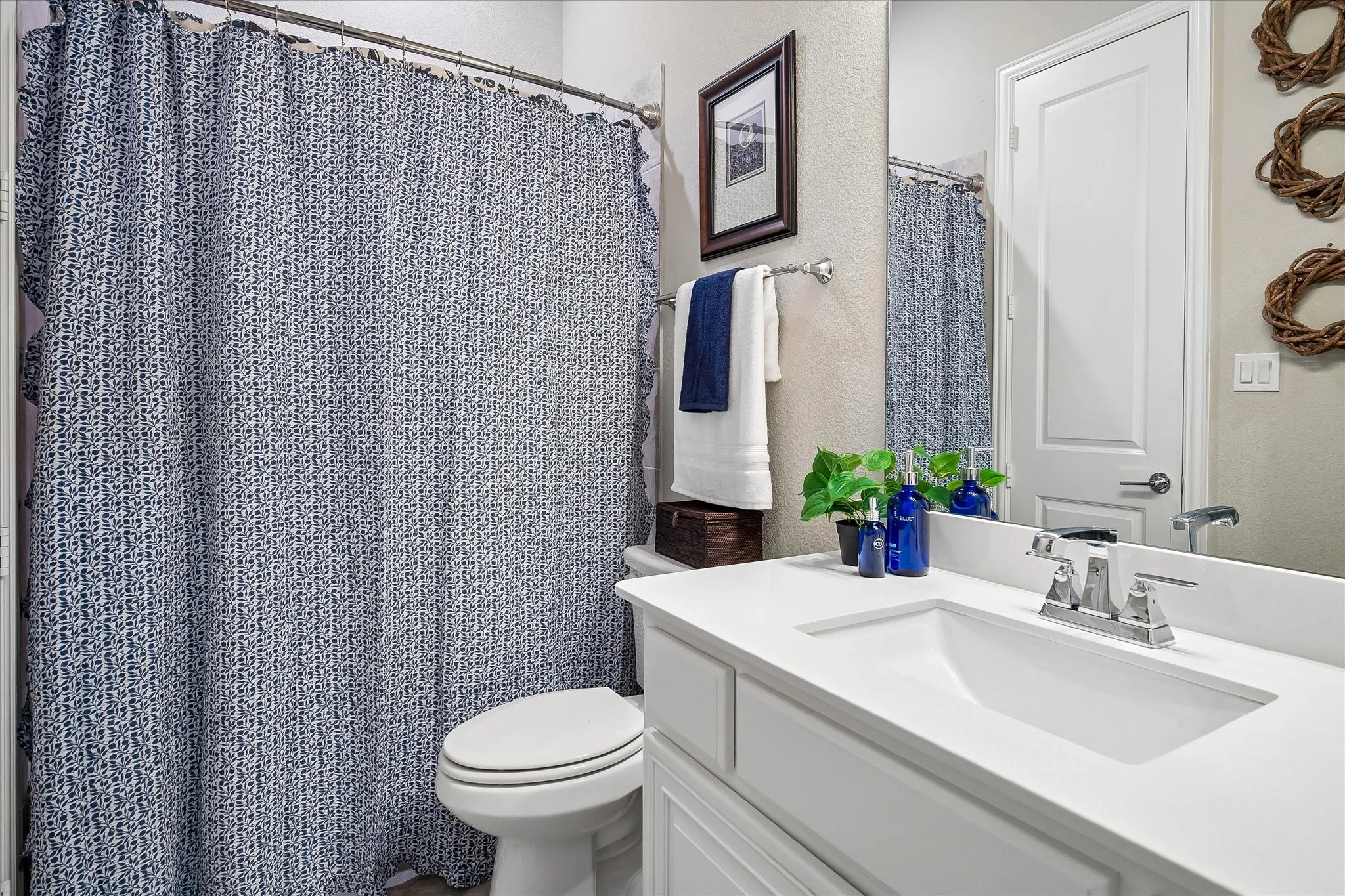 Bathroom featuring a white vanity with an integrated sink, chrome faucet, and a wall-mounted mirror
