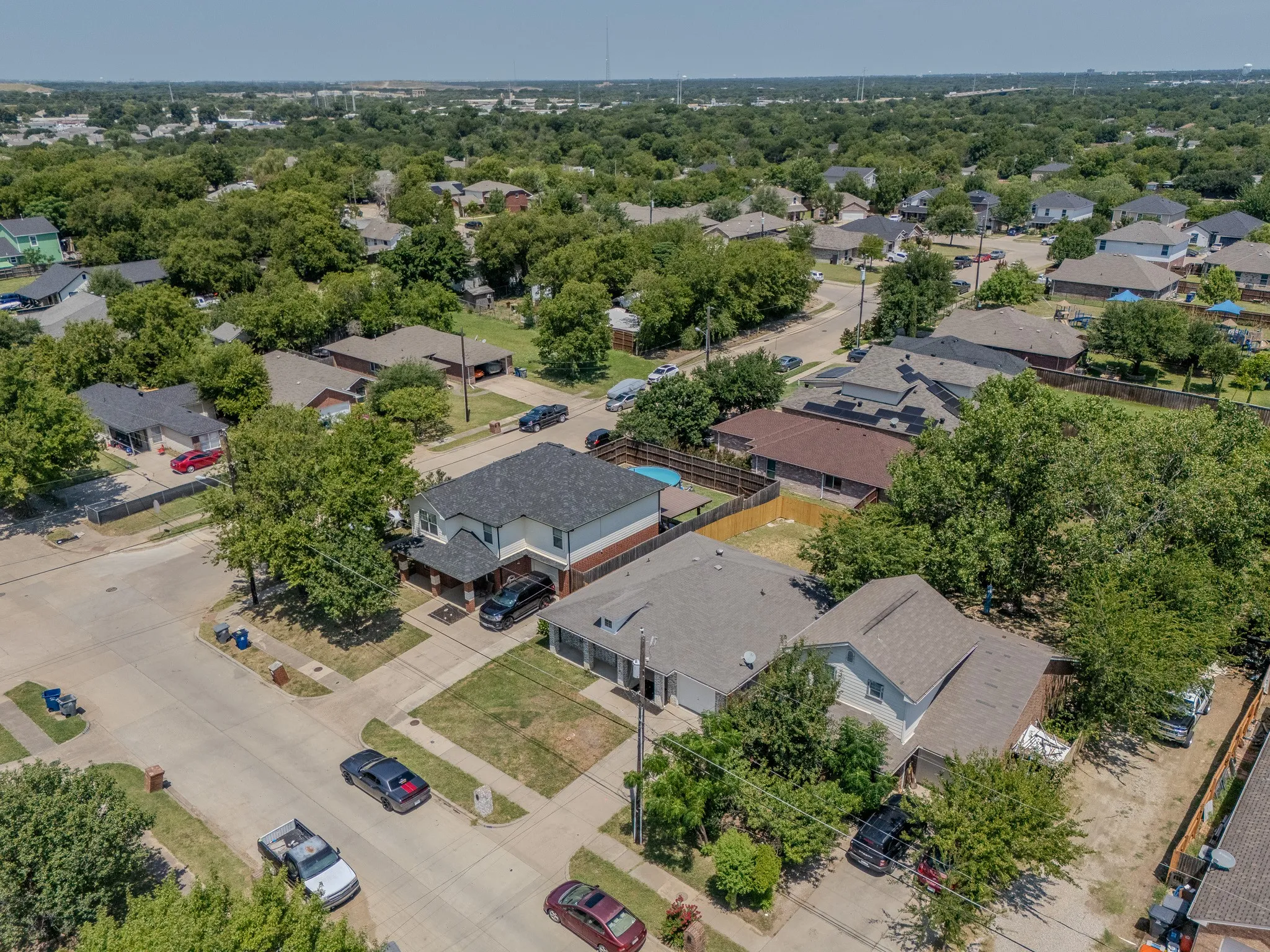 Aerial perspective showcasing a residential street with mature trees