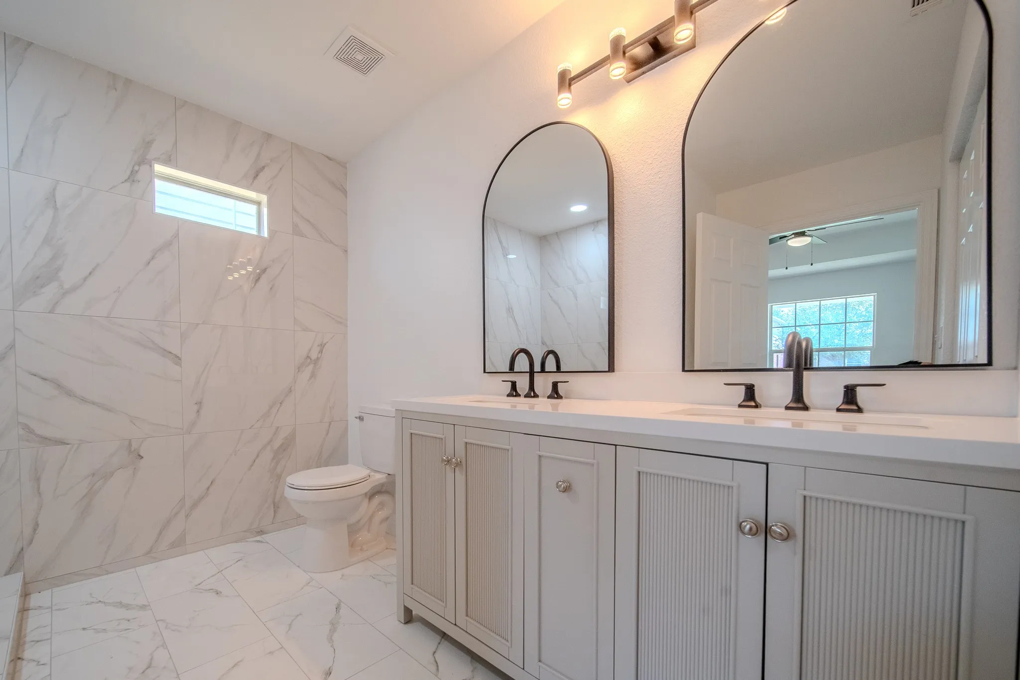 Double vanity with white countertops, undermount sinks, and matte black fixtures