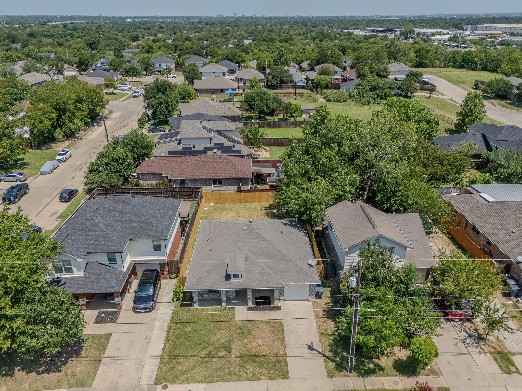 Aerial overview of a residential neighborhood featuring several properties with mature landscaping