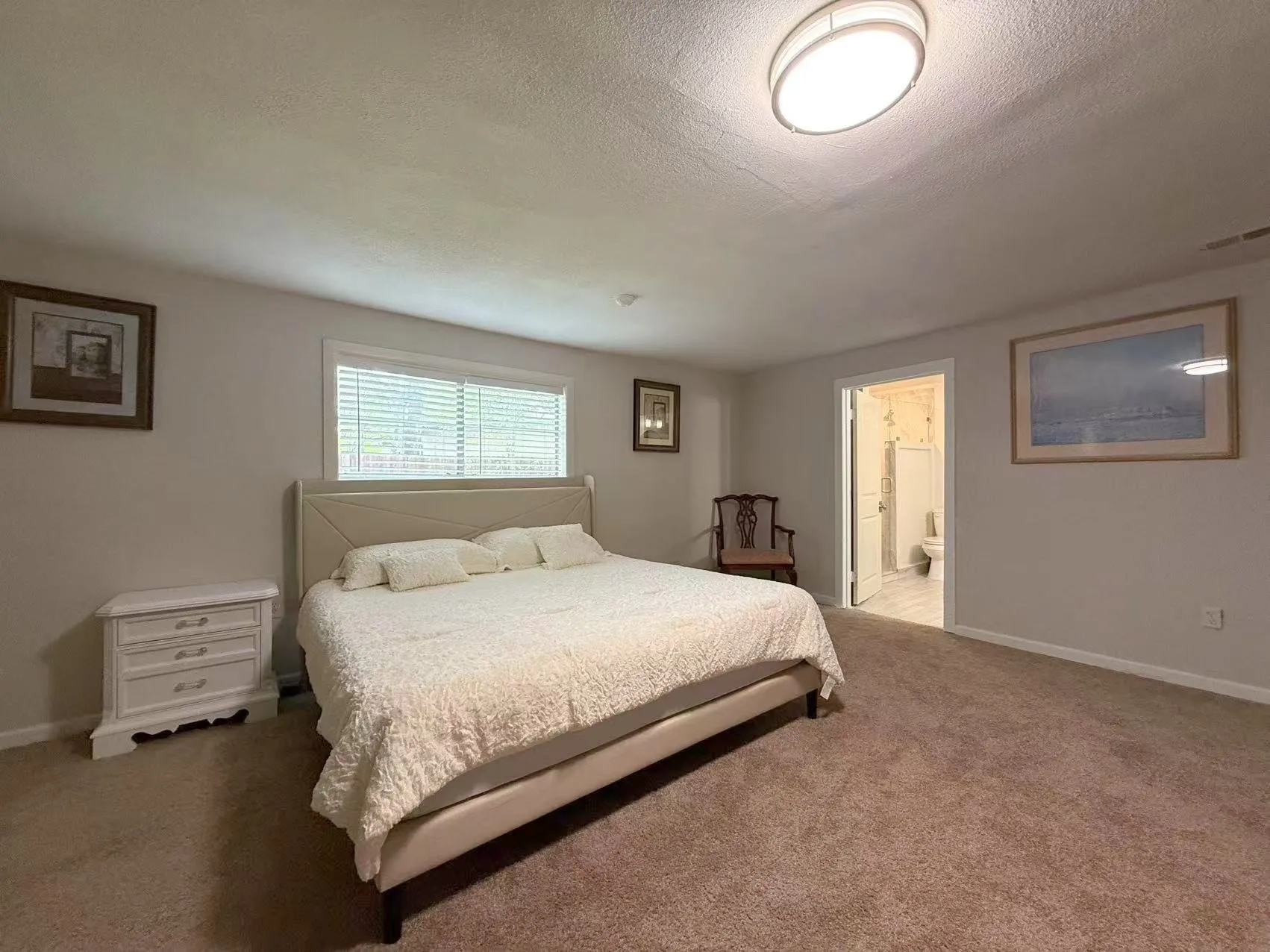 Carpeted room with neutral wall tones and a window featuring horizontal blinds