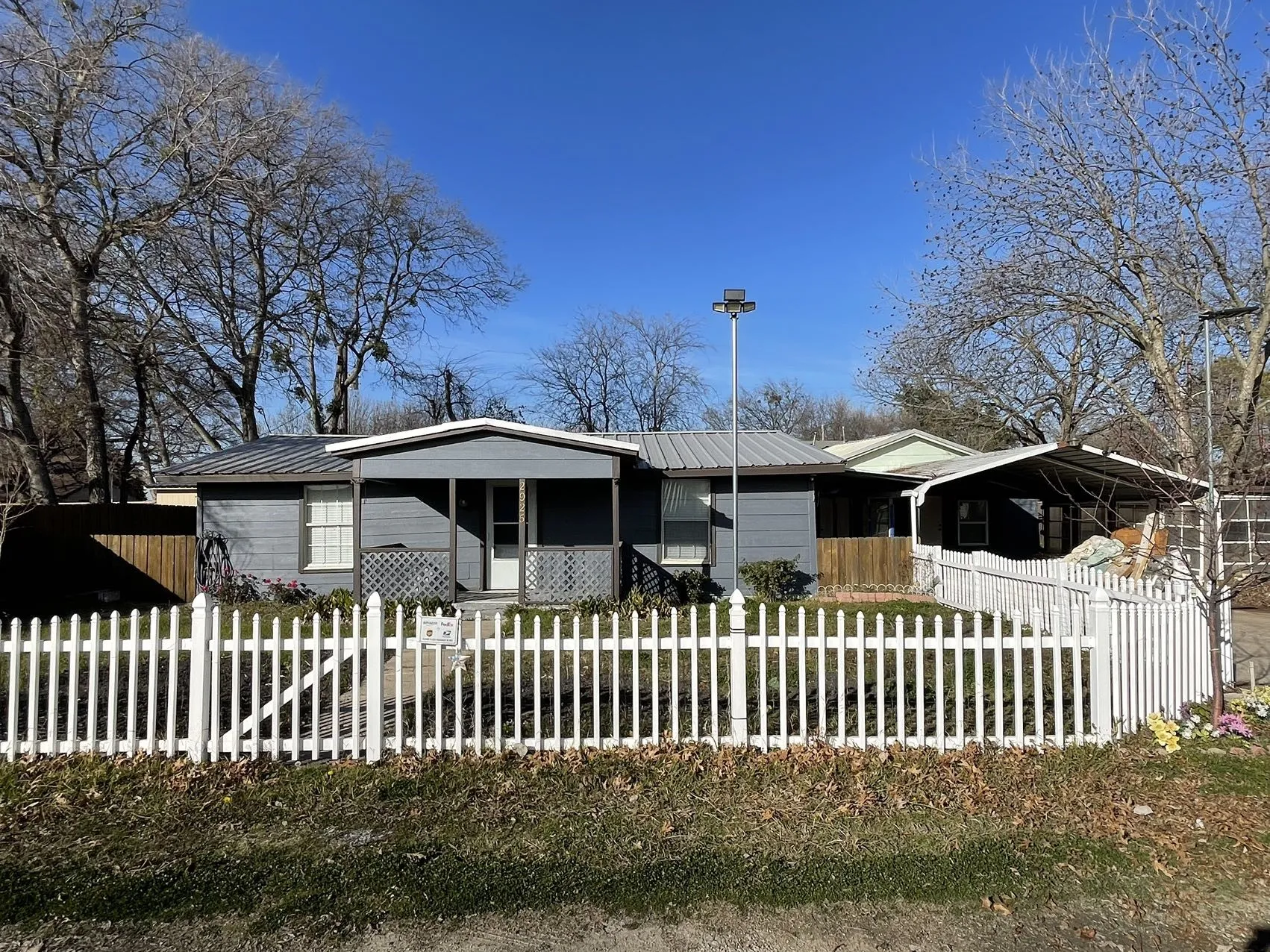 Single-story residence featuring a gray exterior and a corrugated metal roof