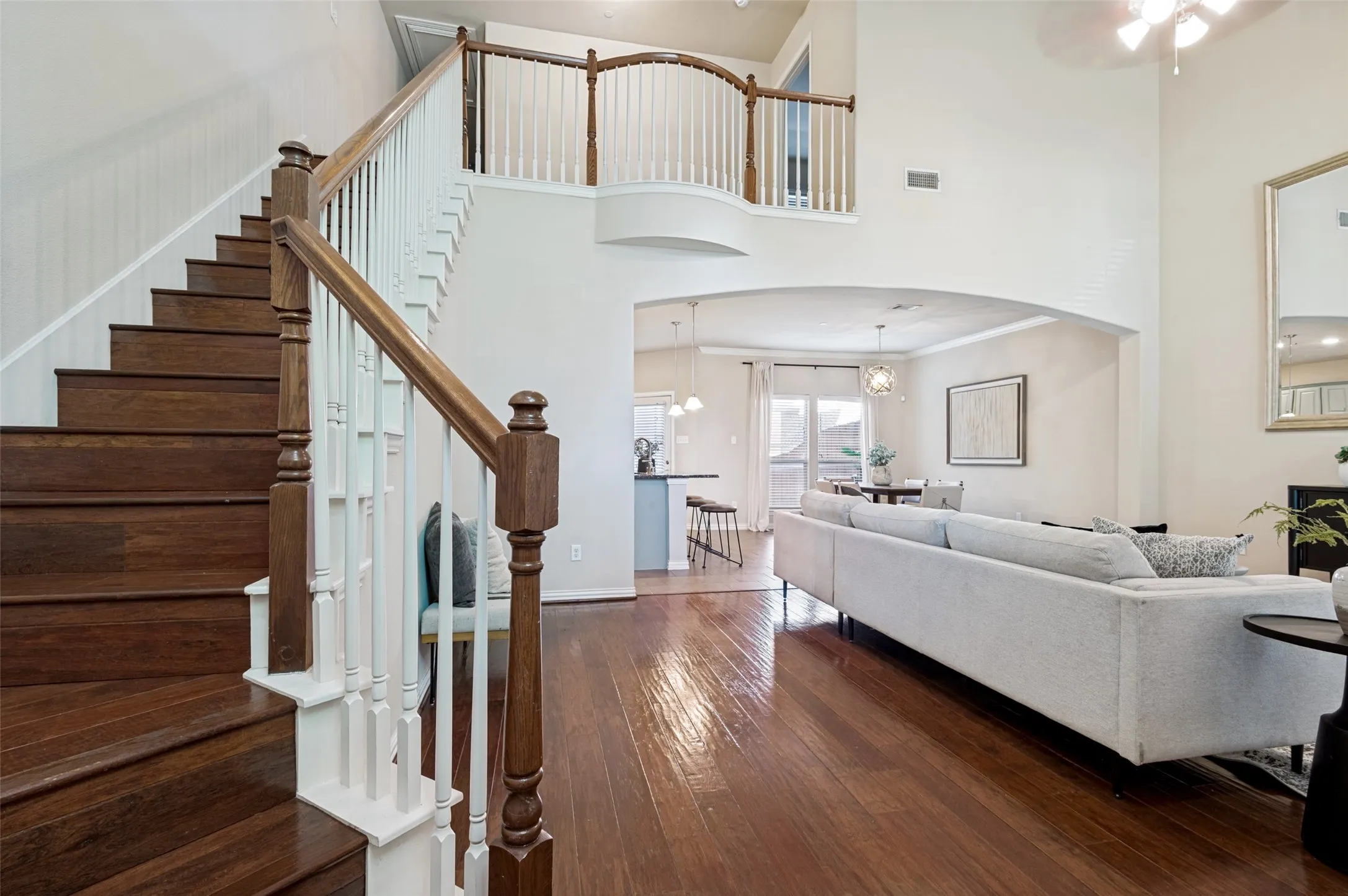Entrance Foyer perspective highlighting the curved staircase, open railing, and seamless flow between the home's gathering spaces.