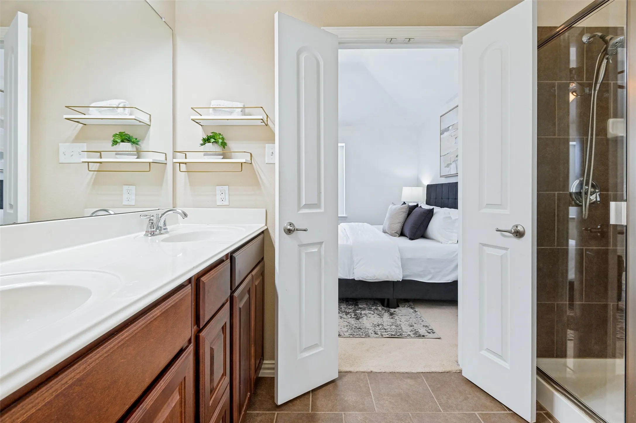 Bathroom featuring a dual vanity with a white countertop and wood-finish cabinetry