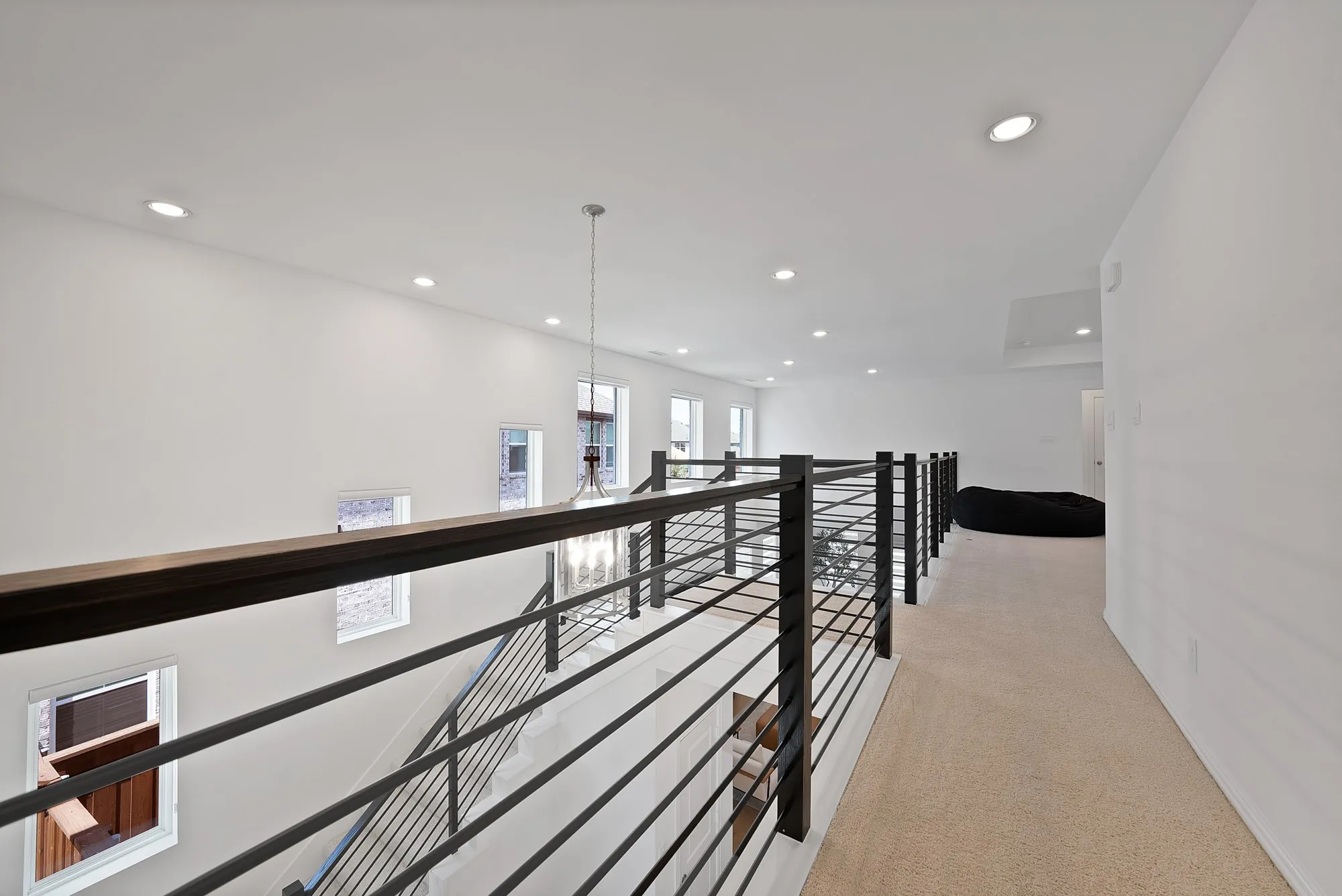Upper-level landing featuring a contemporary metal railing system