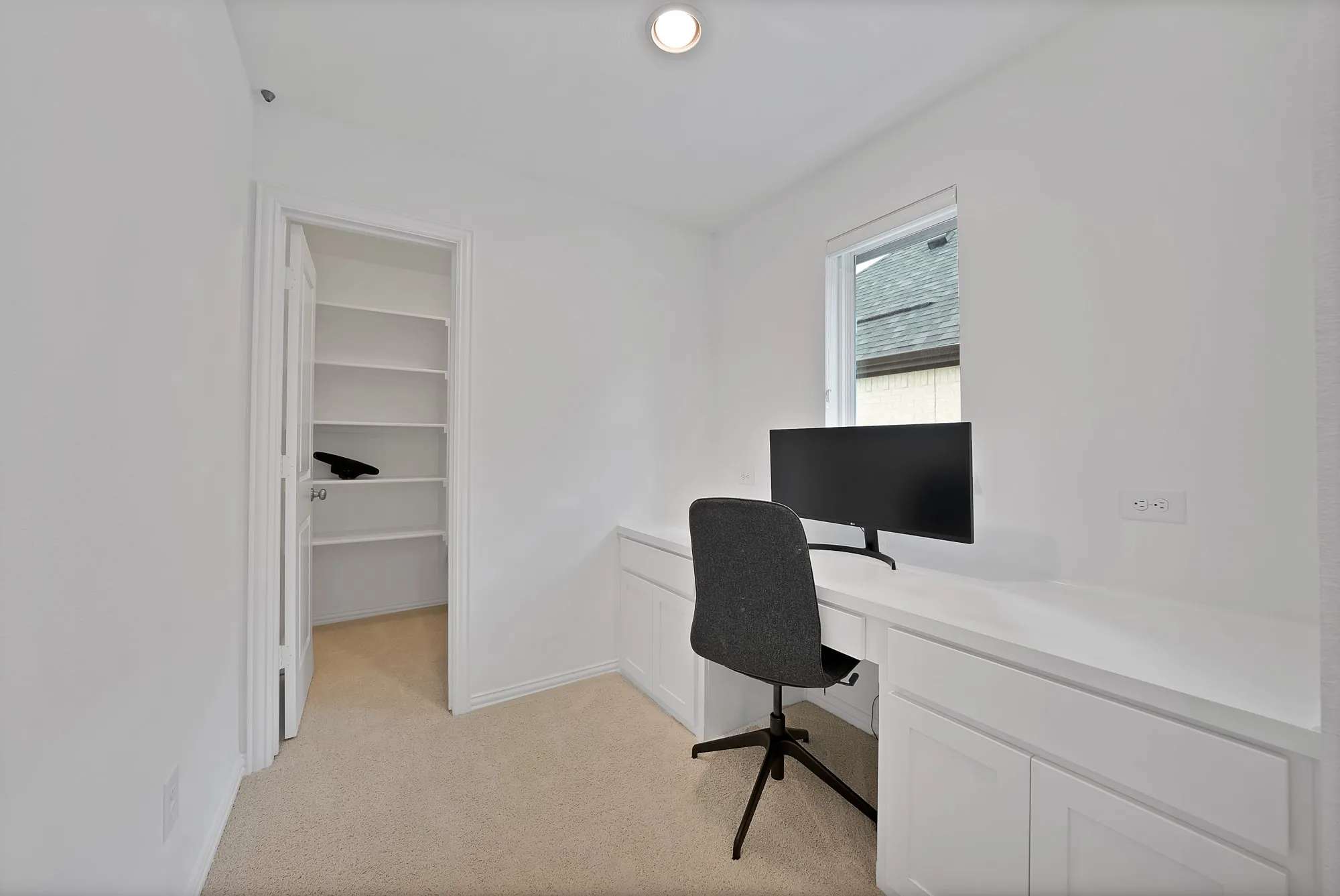 Dedicated workspace featuring a built-in desk, under-cabinet storage, and recessed lighting