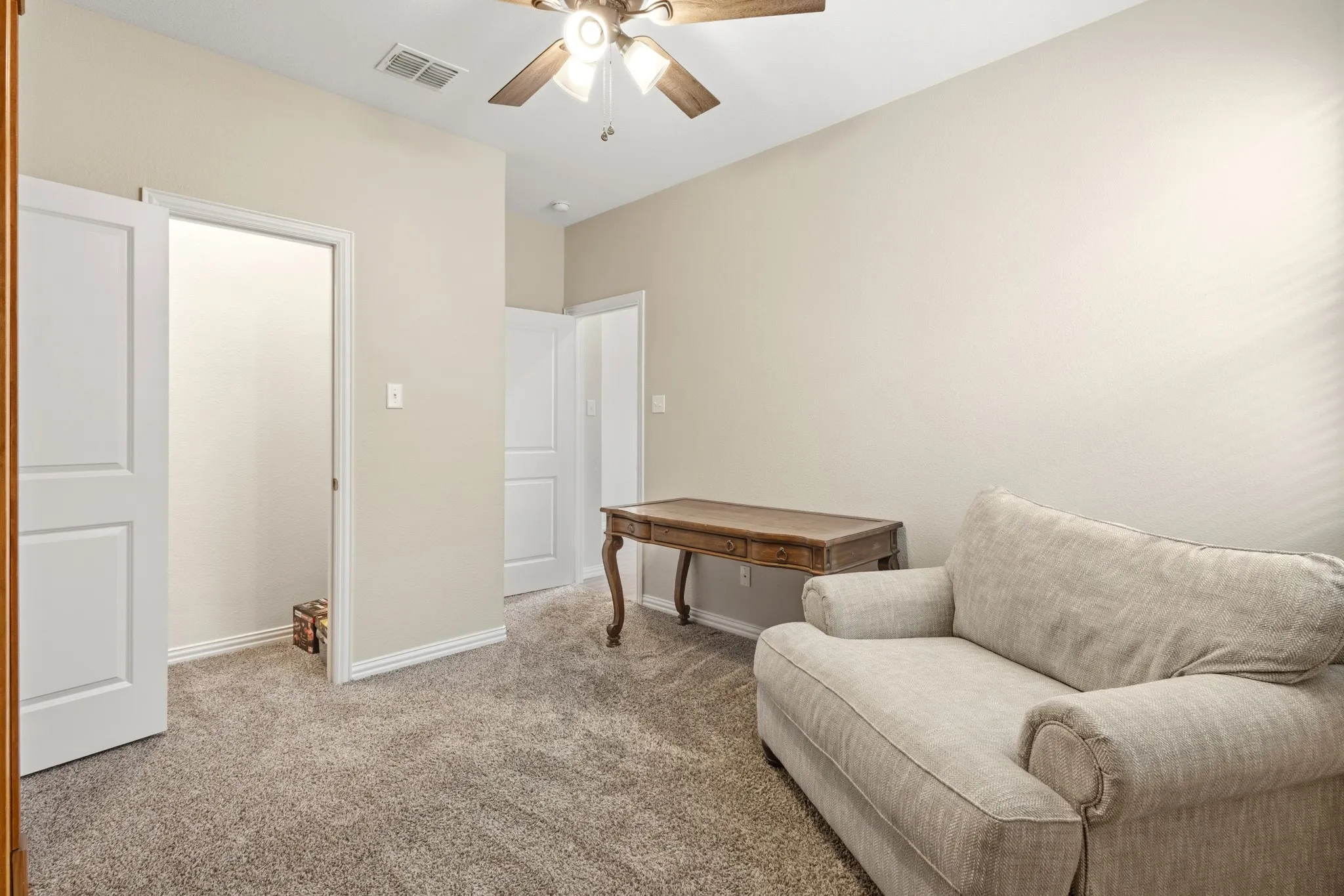 Neutral-toned room featuring light beige walls and grey carpet
