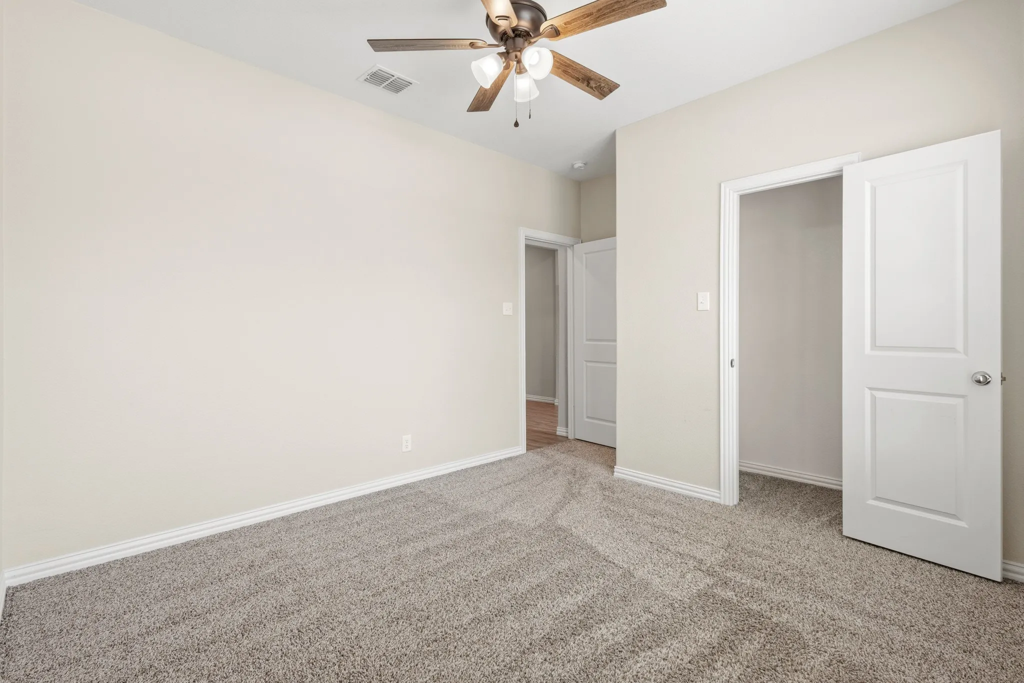 Neutral-toned walls complement the gray carpeting