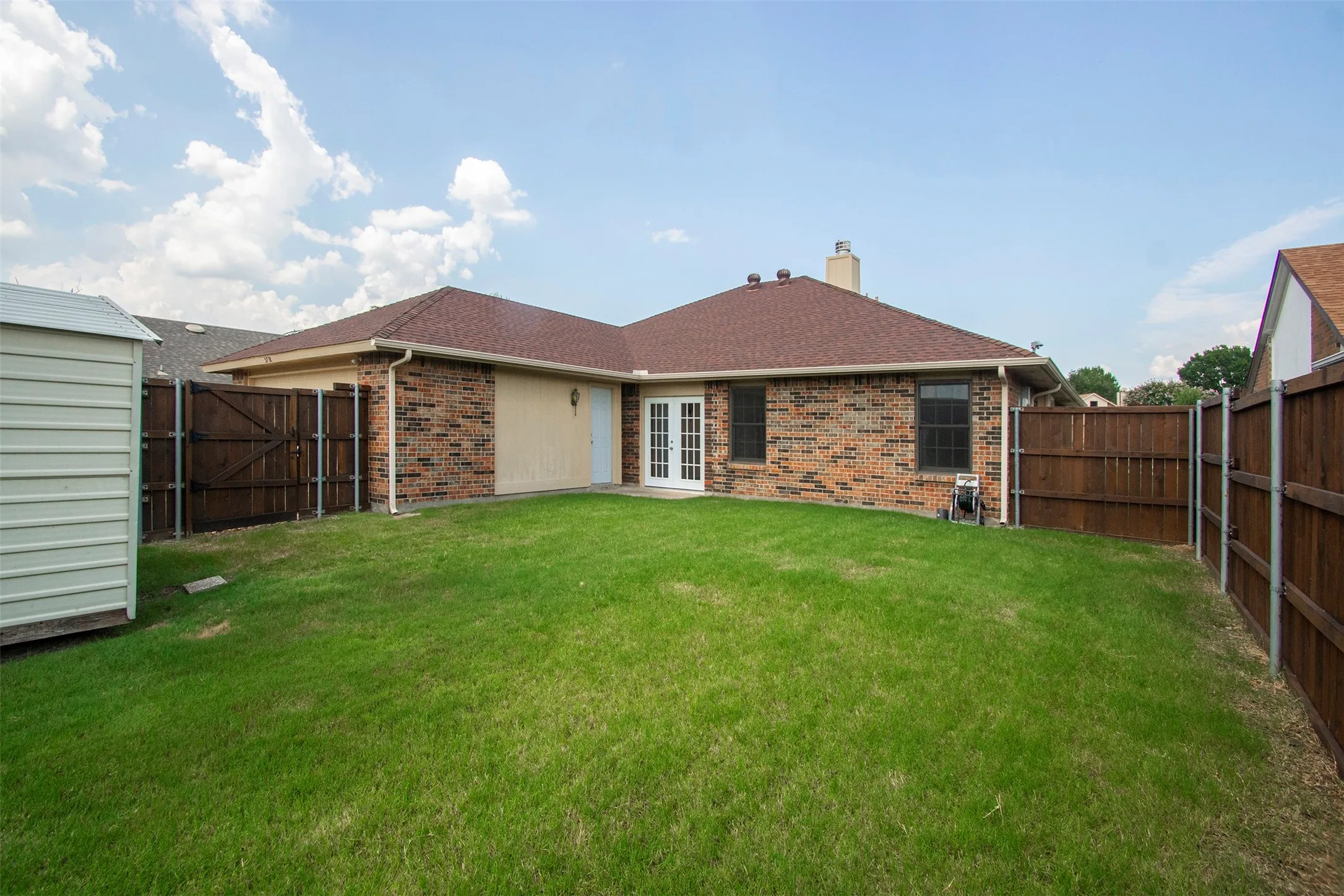 Expansive backyard featuring a lush lawn and a privacy fence
