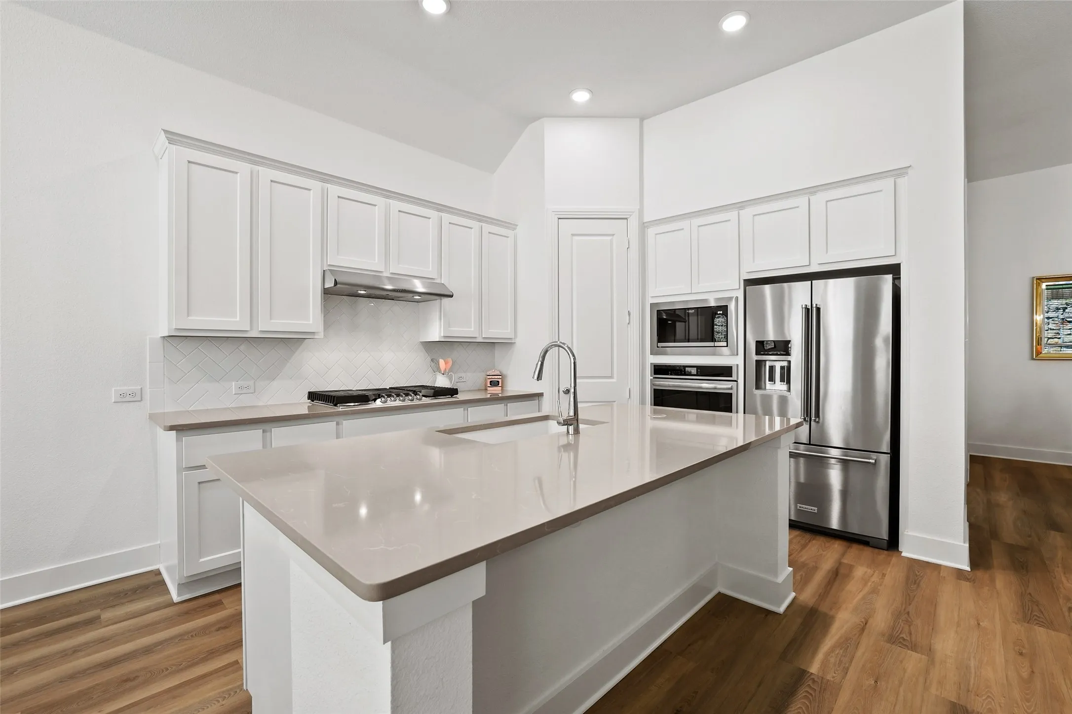 Quartz countertops with light veining are a highlight of the kitchen