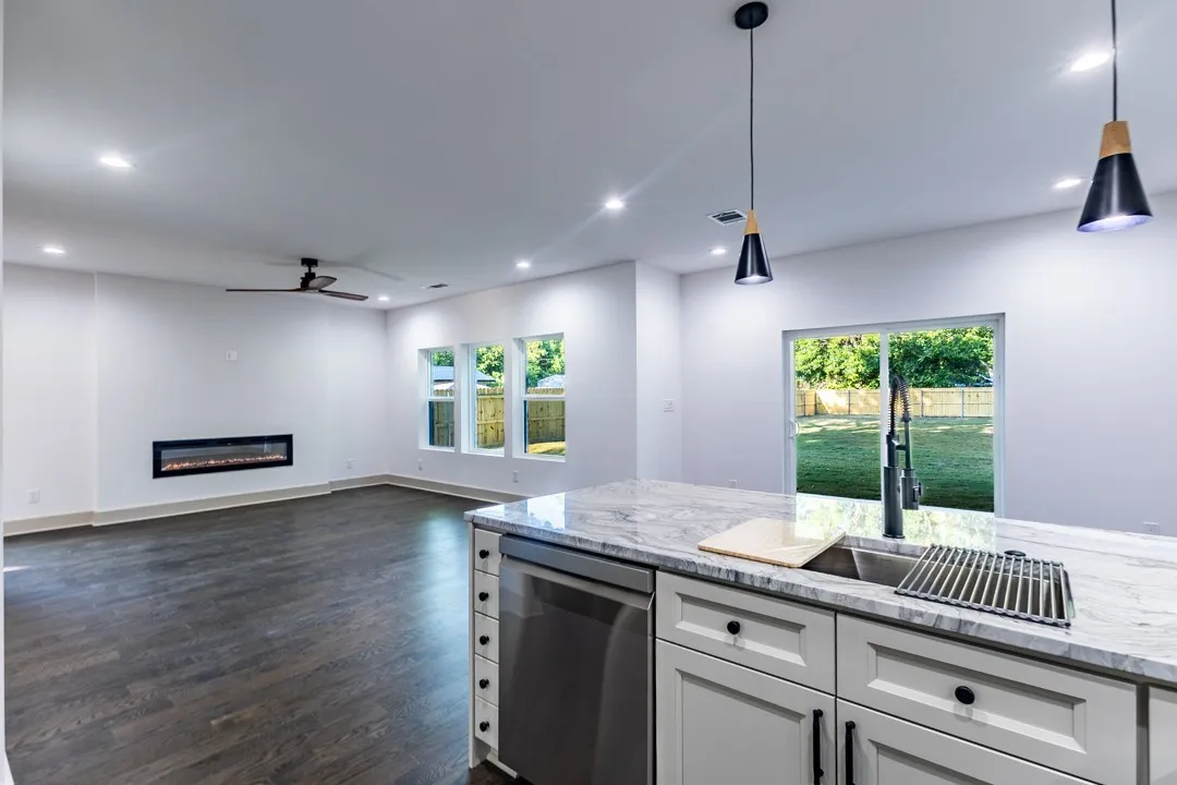 Open-concept interior featuring wood-finish flooring, recessed lighting, and a linear electric fireplace