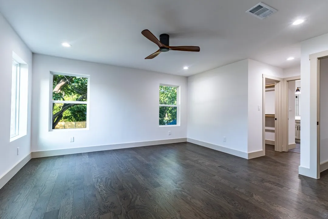 Spacious room featuring dark wood-finish flooring, recessed lighting, and a modern ceiling fan