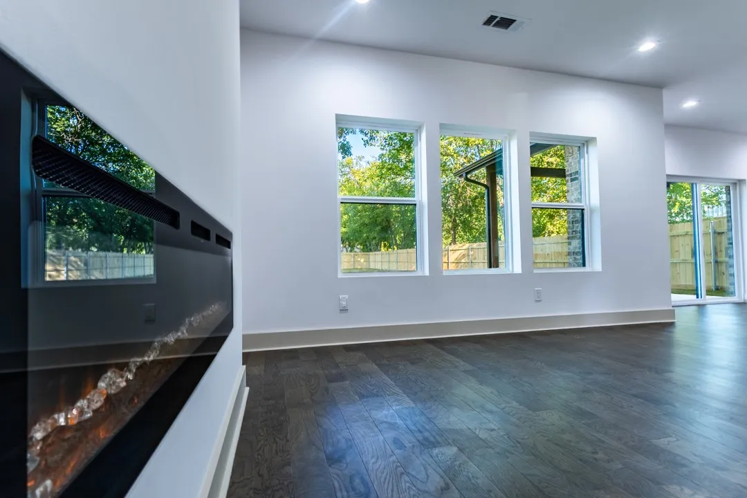 Electric fireplace and large windows frame the living room