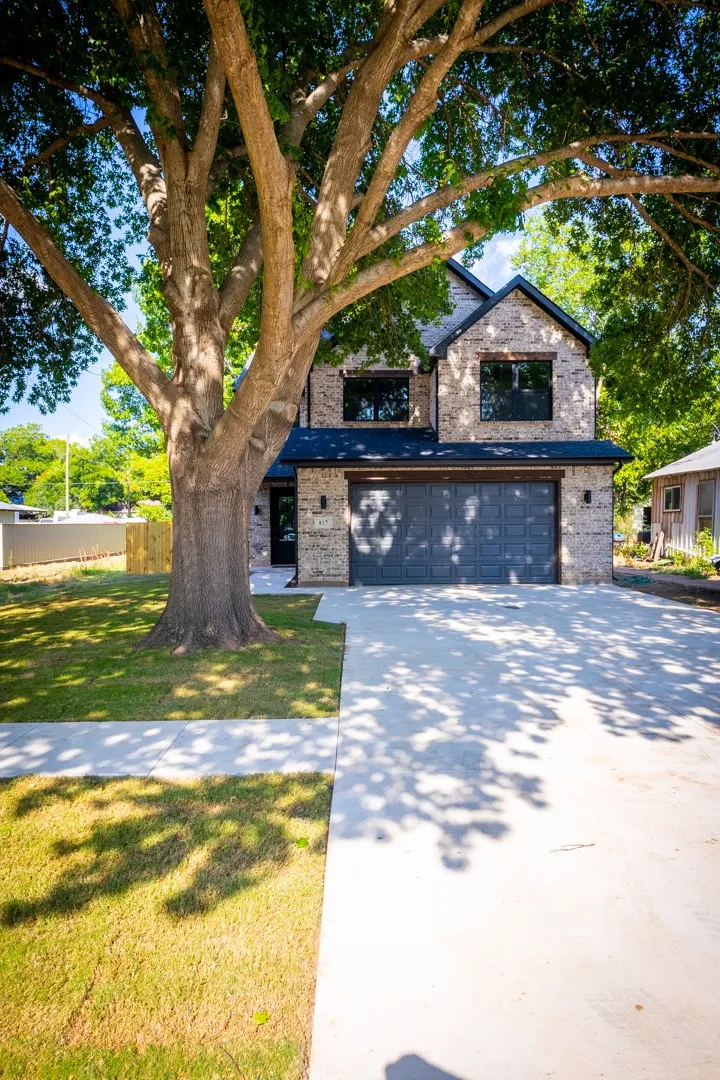 Extra wide driveway and new sidewalk frame the mature maple tree