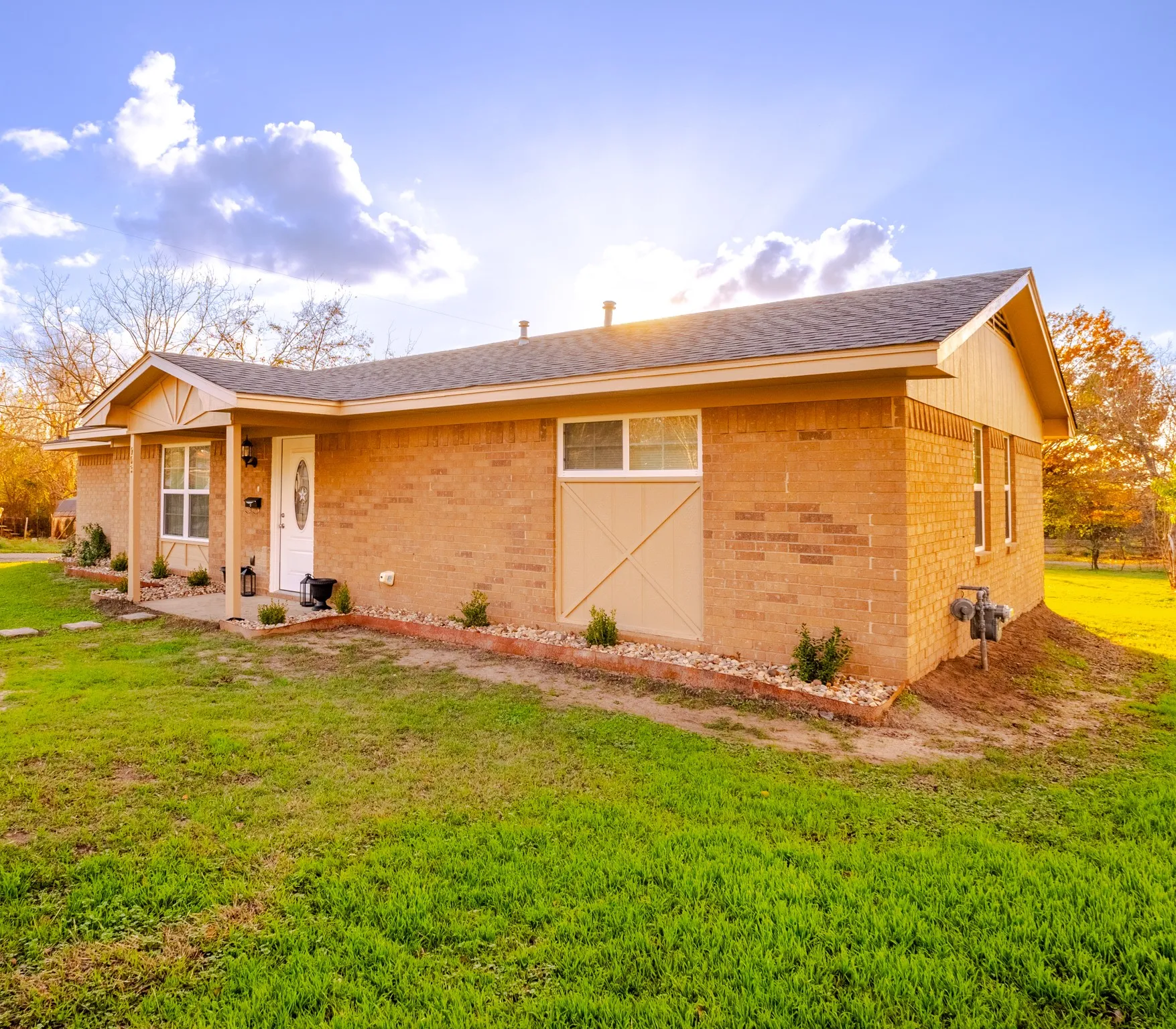 Brick exterior with a covered front porch and a white entry door