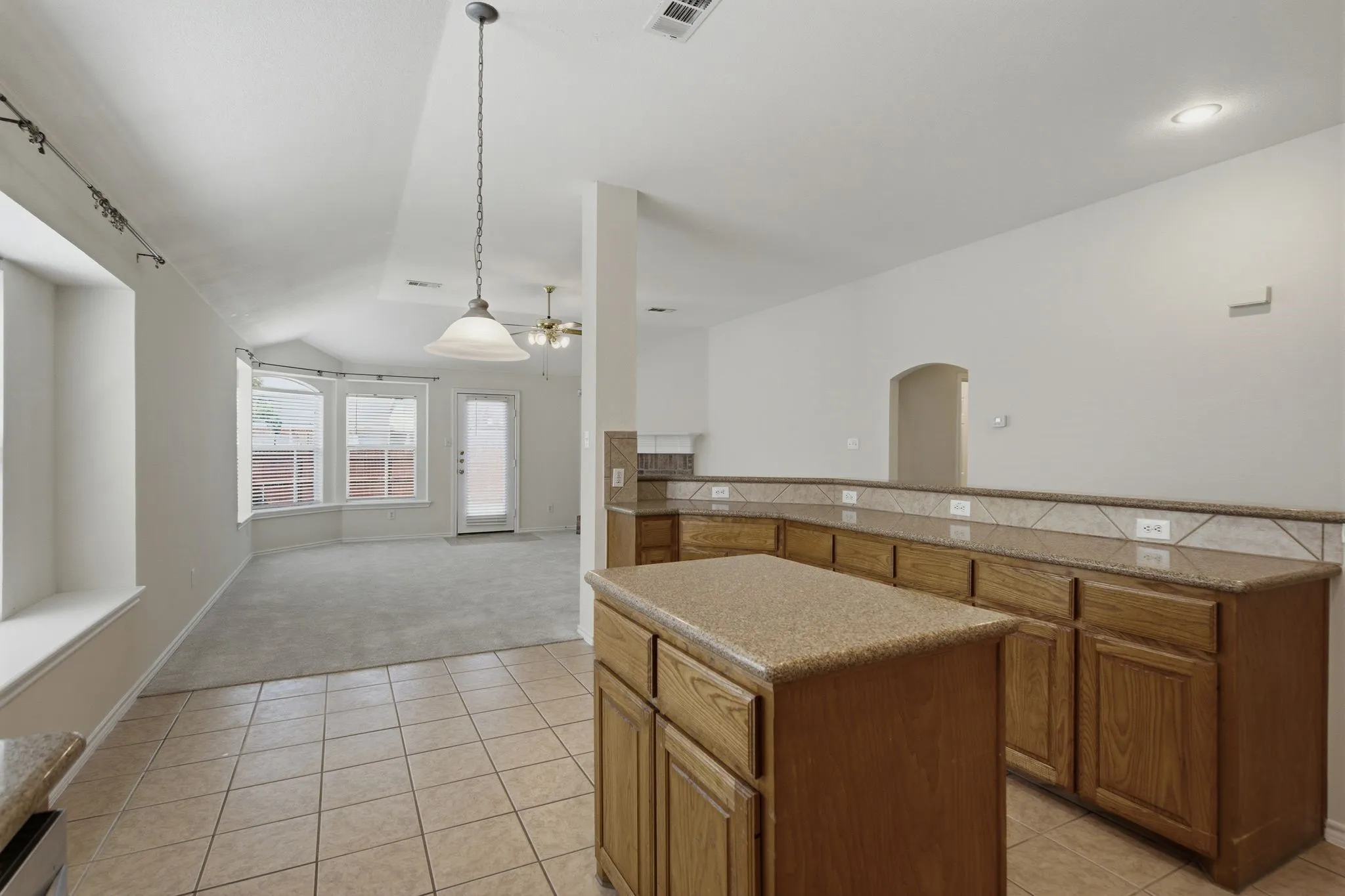 Kitchen island with wood-finish cabinetry showing the breakfast area.