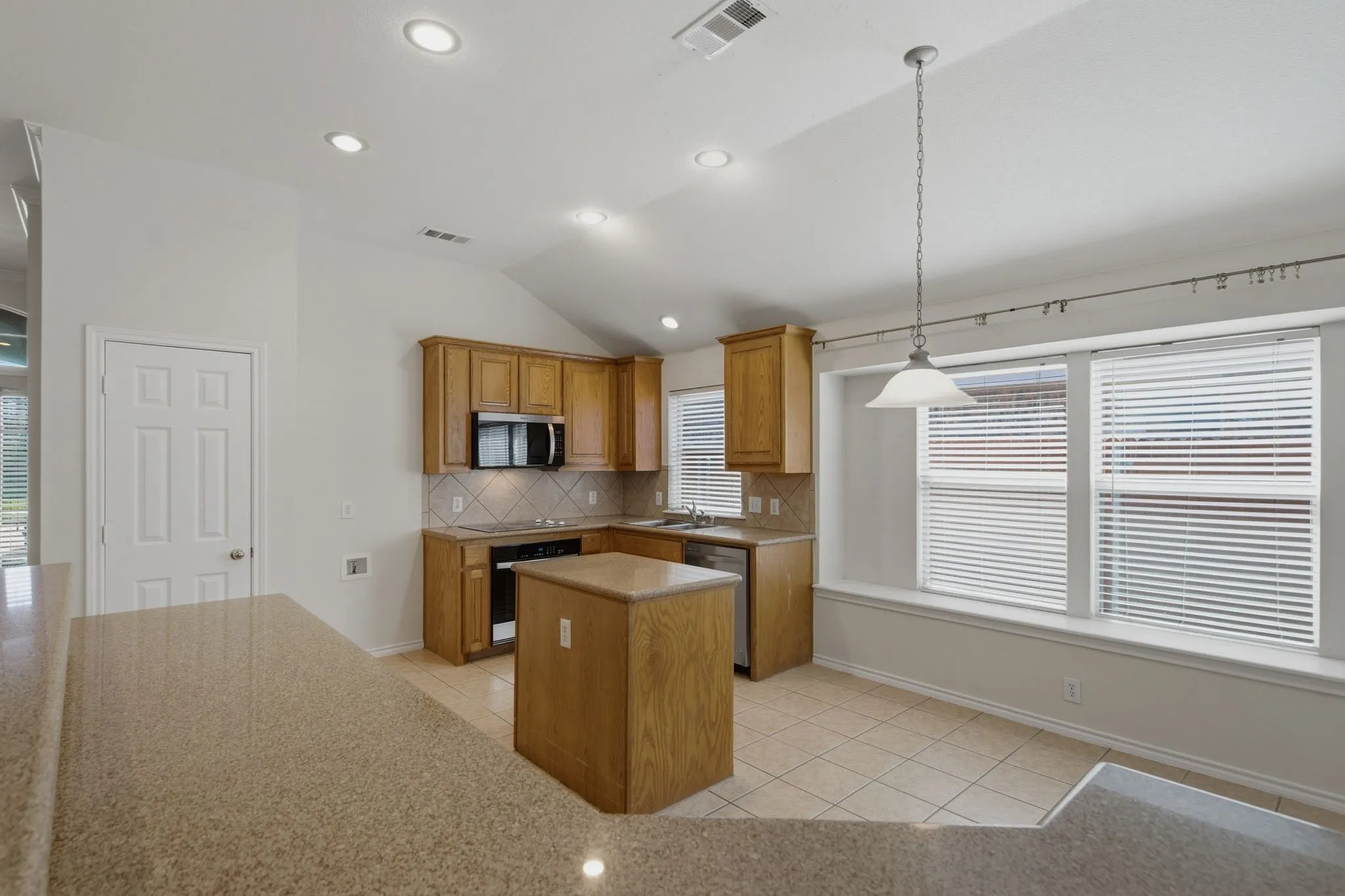 Kitchen featuring wood cabinetry, stainless steel appliances, and a tiled backsplash