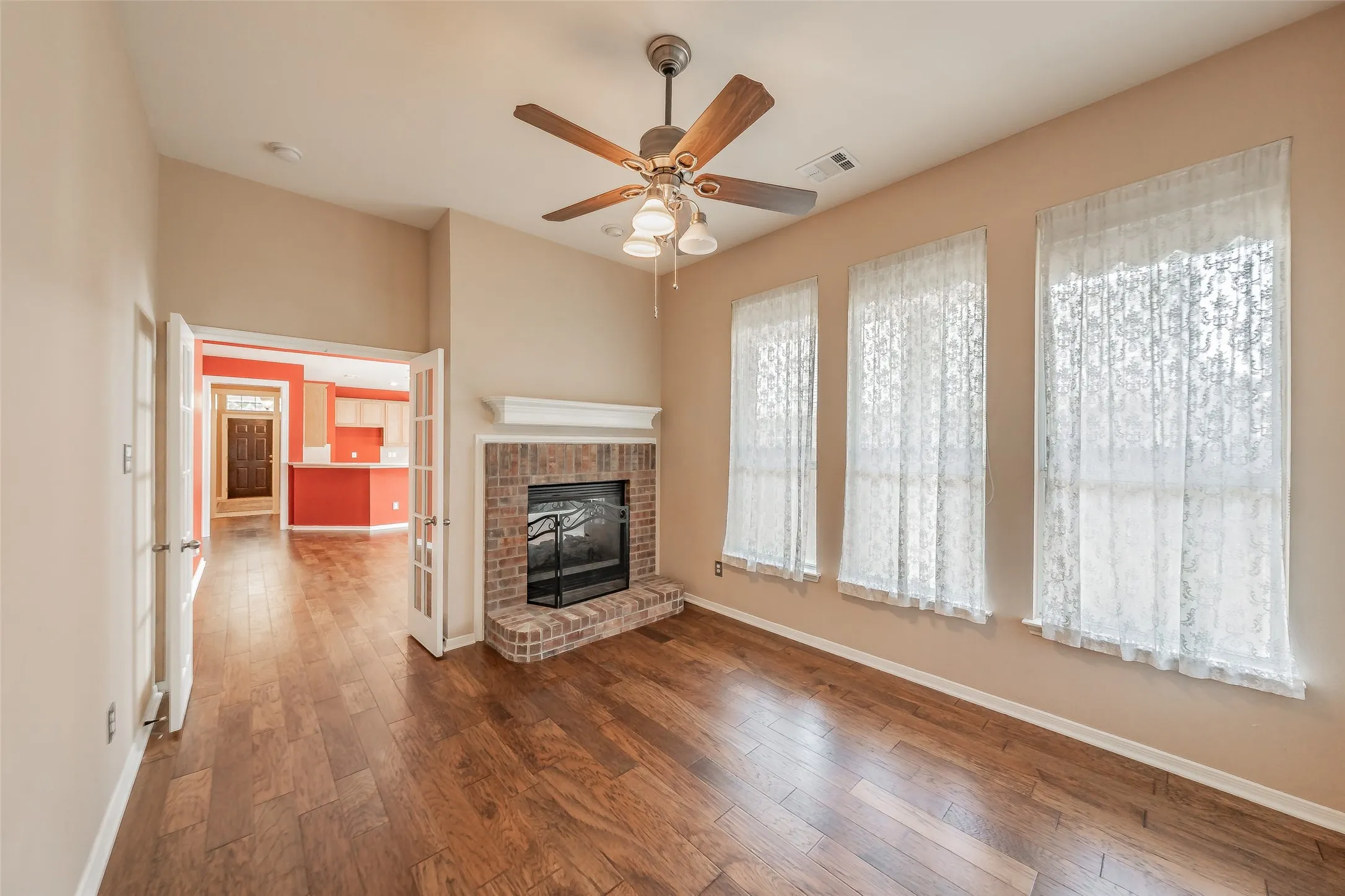 Versatile sunroom or private home office with wood flooring, fireplace and abundant natural light.