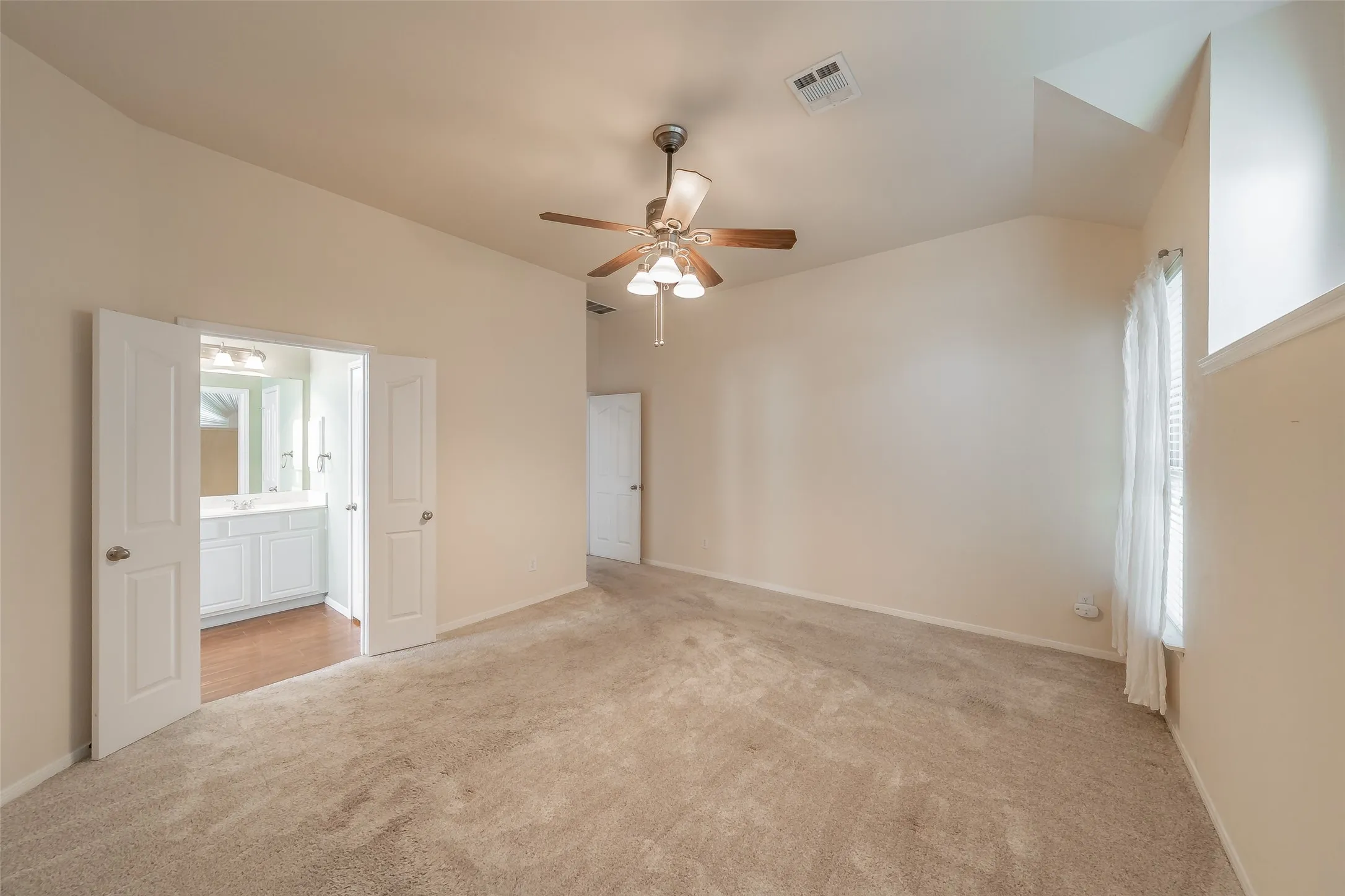 Primary suite offers a vaulted ceiling, generous floor space and direct access to the private bathroom.