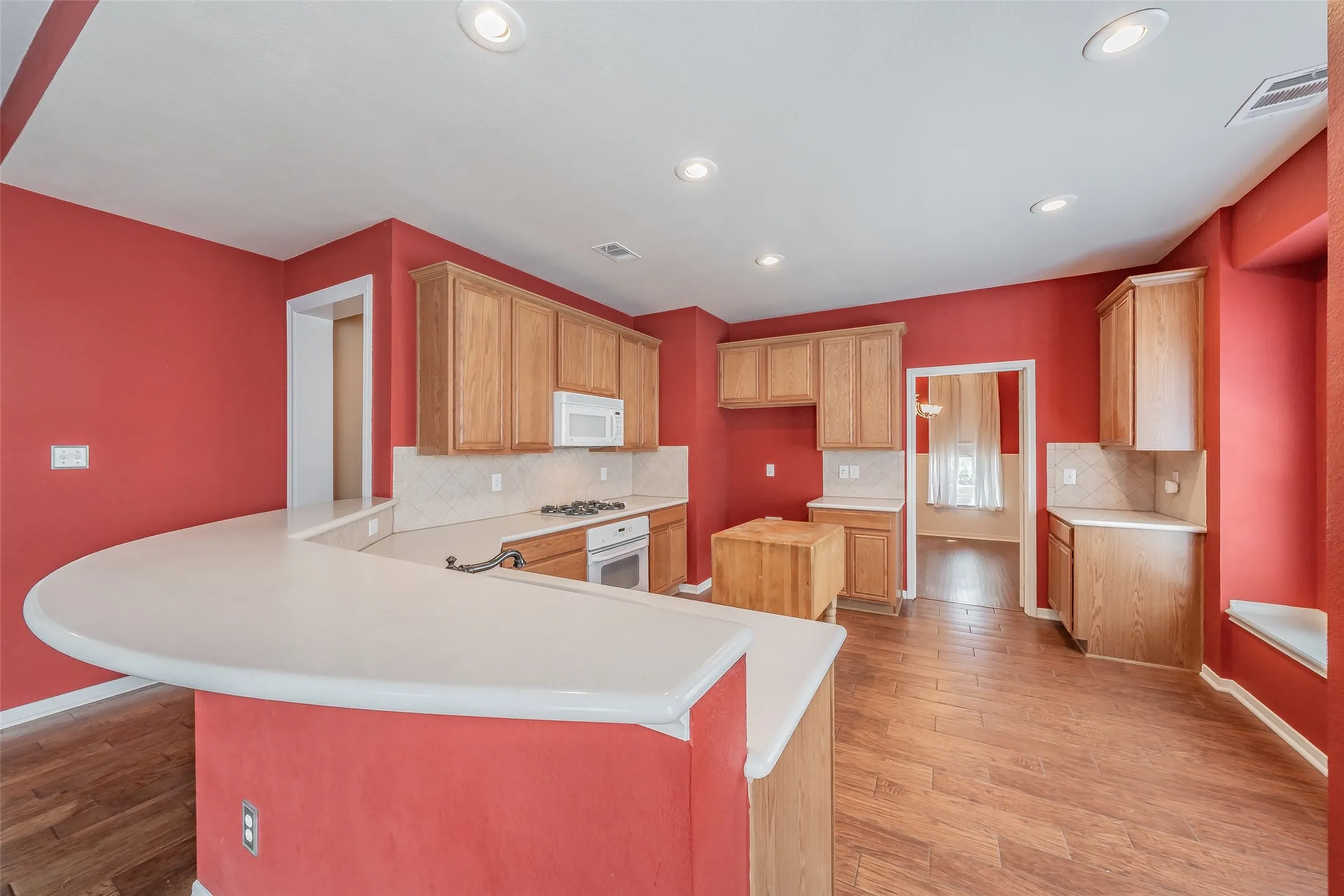 Open kitchen layout with wraparound breakfast bar, extensive storage and recessed lighting.