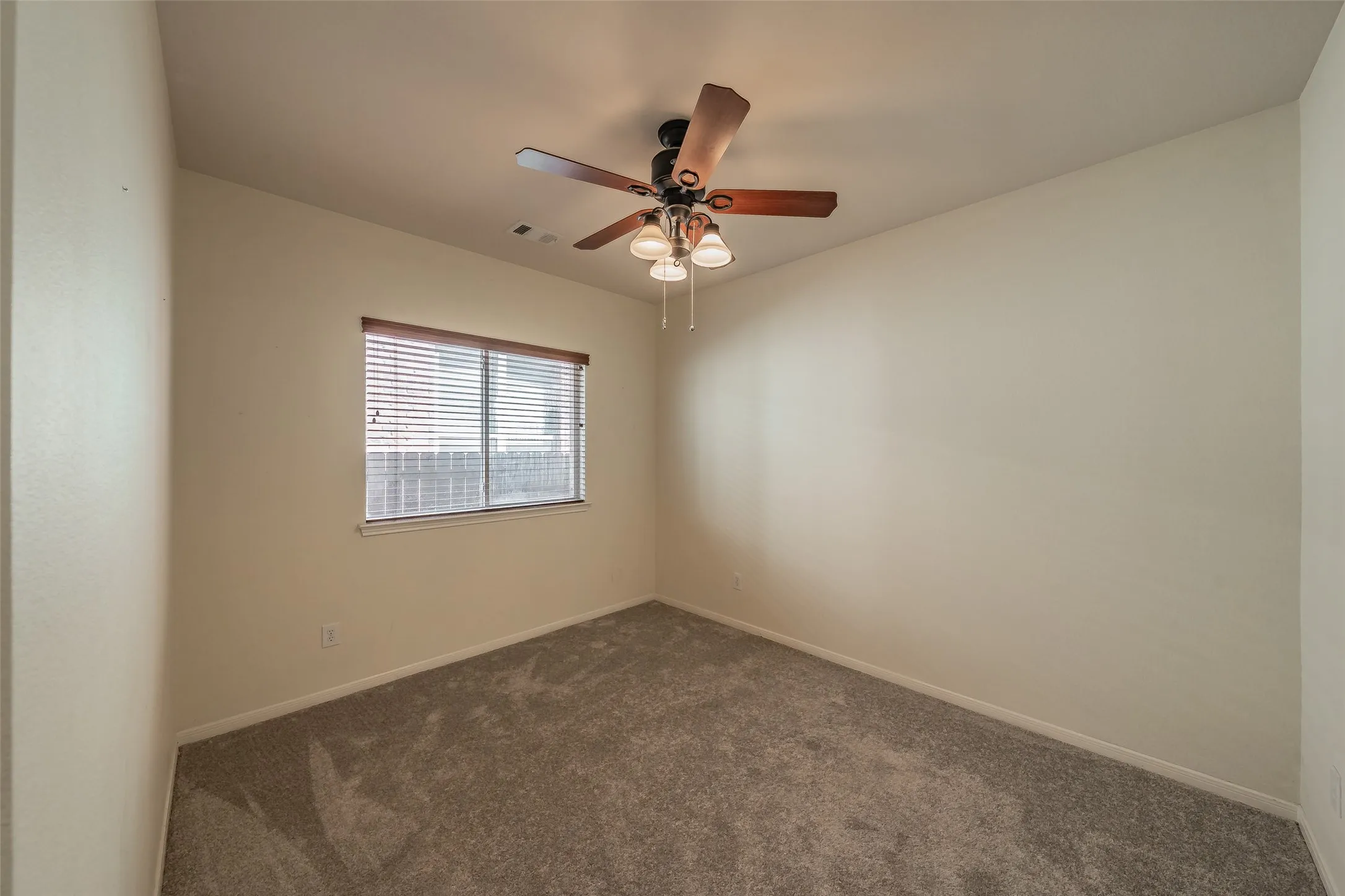 3rd bedroom with fresh carpet, ceiling fan and generous closet storage.