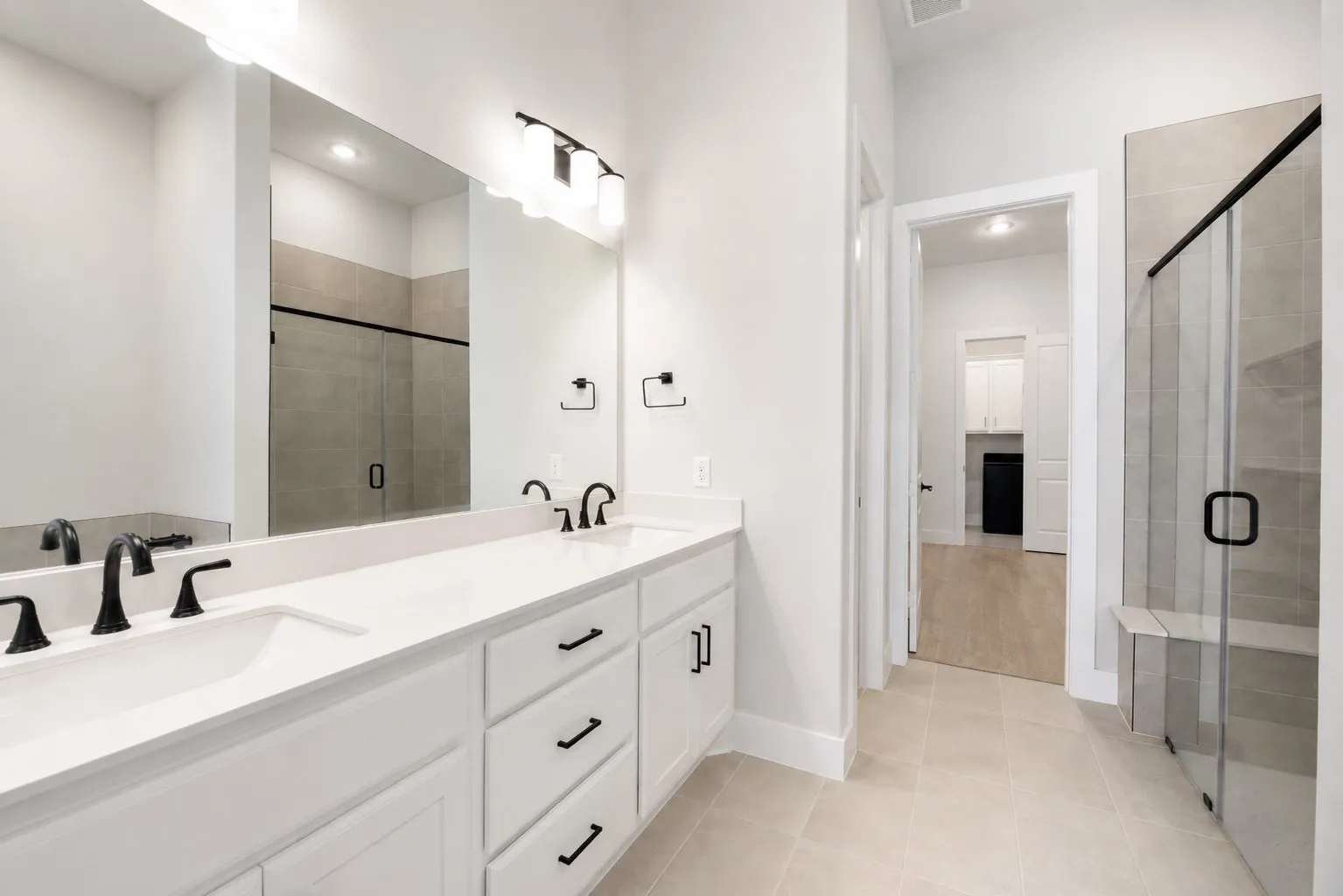 Double vanity featuring white cabinetry, integrated sinks, and matte black fixtures