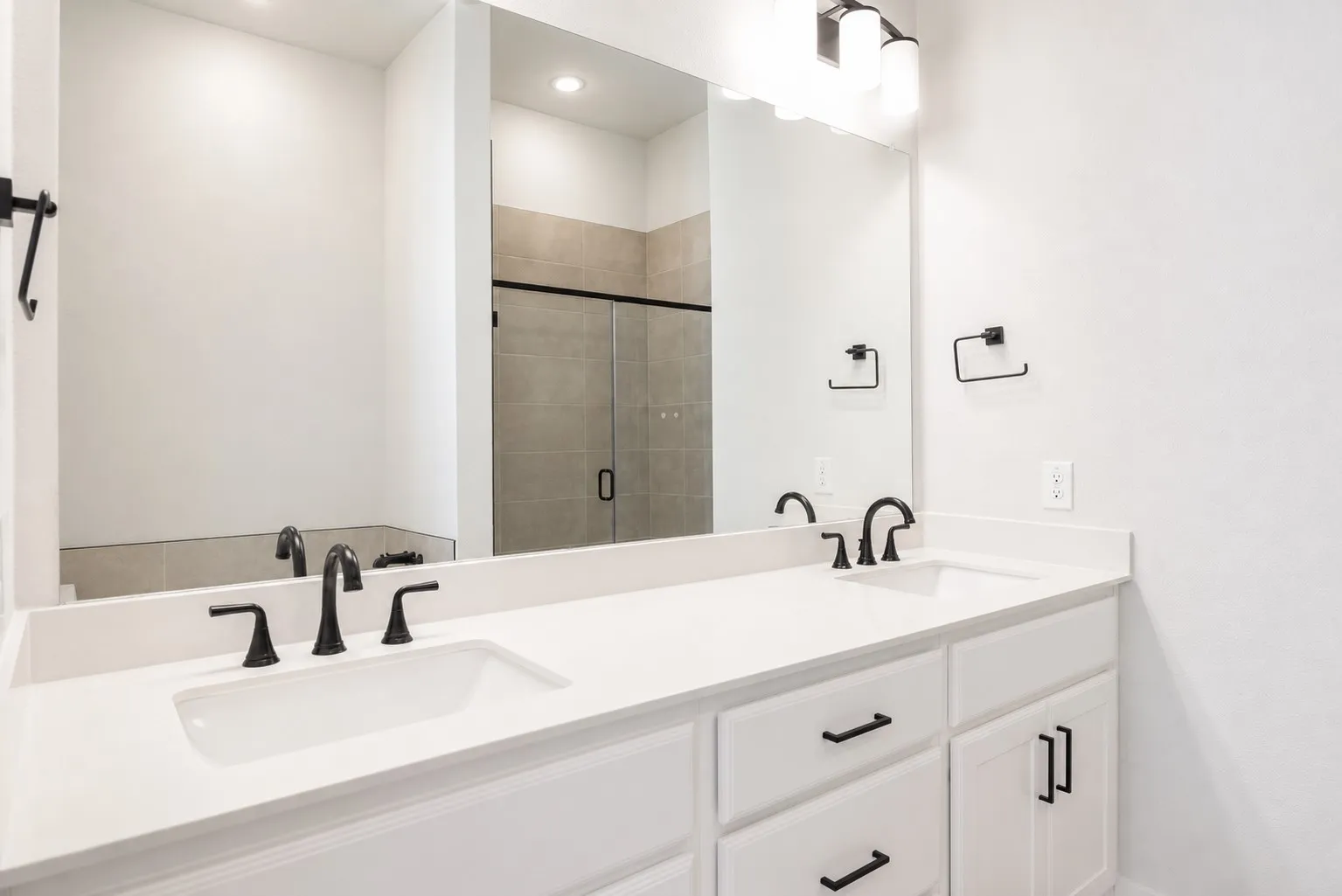 Dual vanity featuring white countertops, undermount sinks, and matte black fixtures