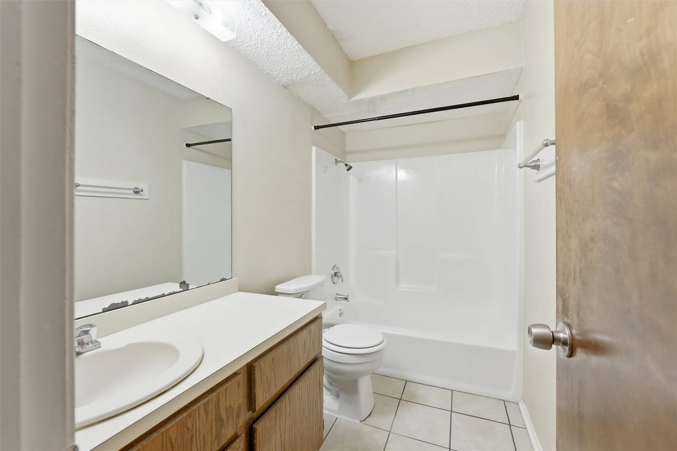 Bathroom featuring a single vanity with wood-finish cabinetry, a white countertop, and an integrated sink