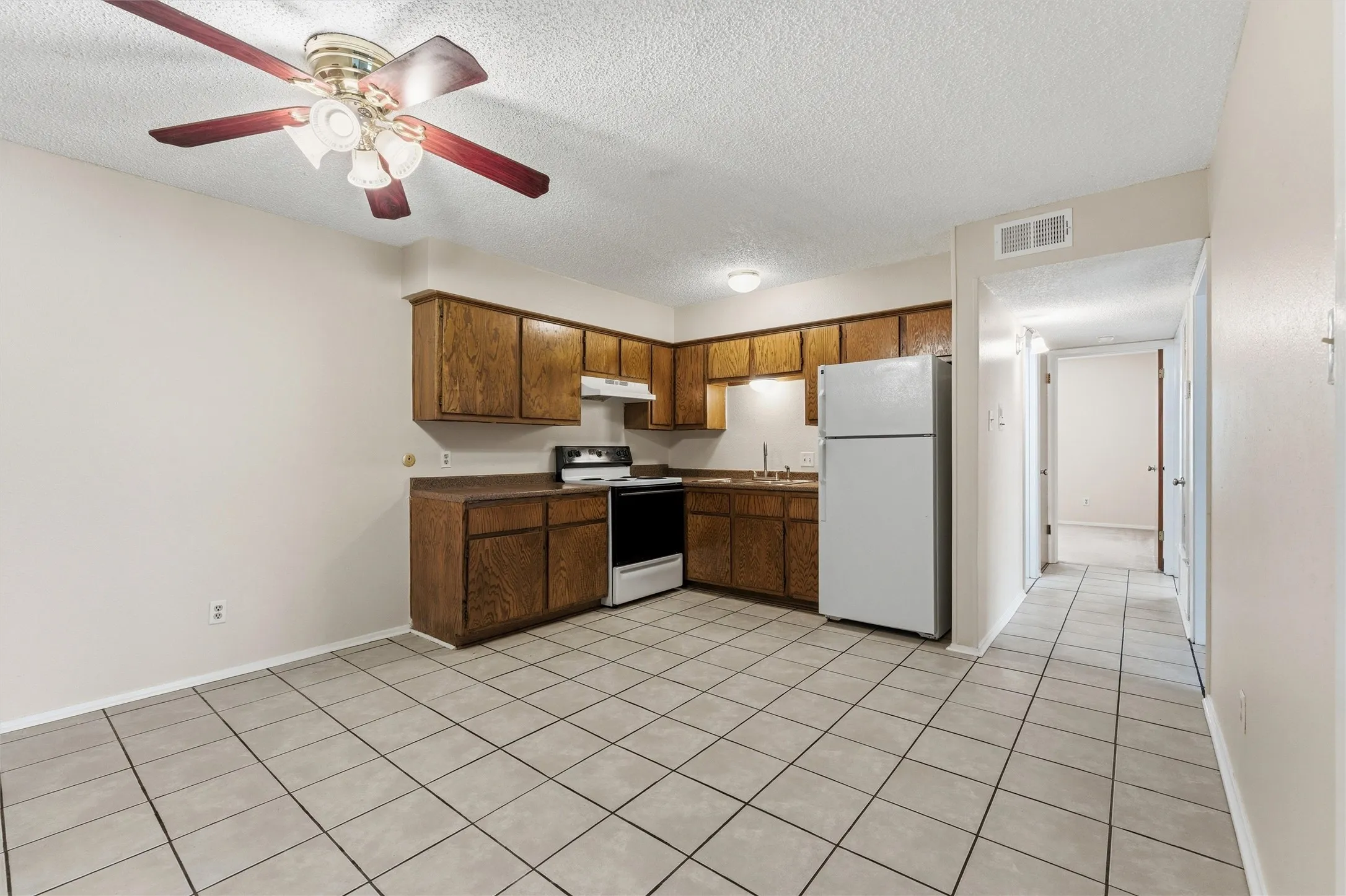 Kitchen featuring wood cabinetry, integrated appliances, and a tiled floor