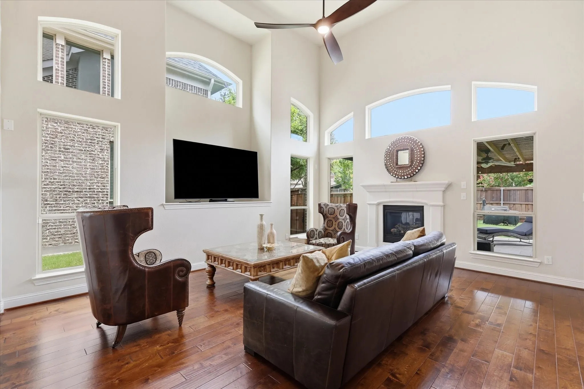 Impressive two-story living room with soaring vaulted ceilings and an abundance of arched windows that fill the space with natural light.