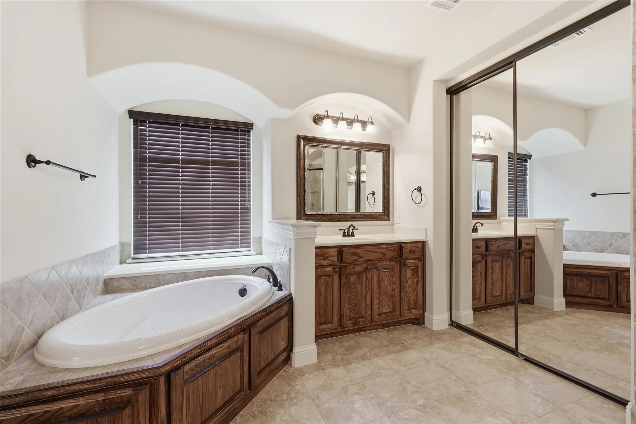 Direct access to the walk-in closet adds convenience, while tile flooring throughout completes this well-appointed retreat.