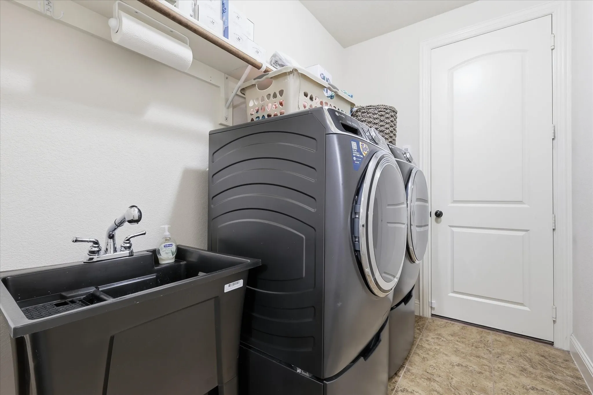 unctional laundry/utility room featuring a deep utility sink, ideal for washing and cleaning tasks, alongside space for a full-size washer and dryer.