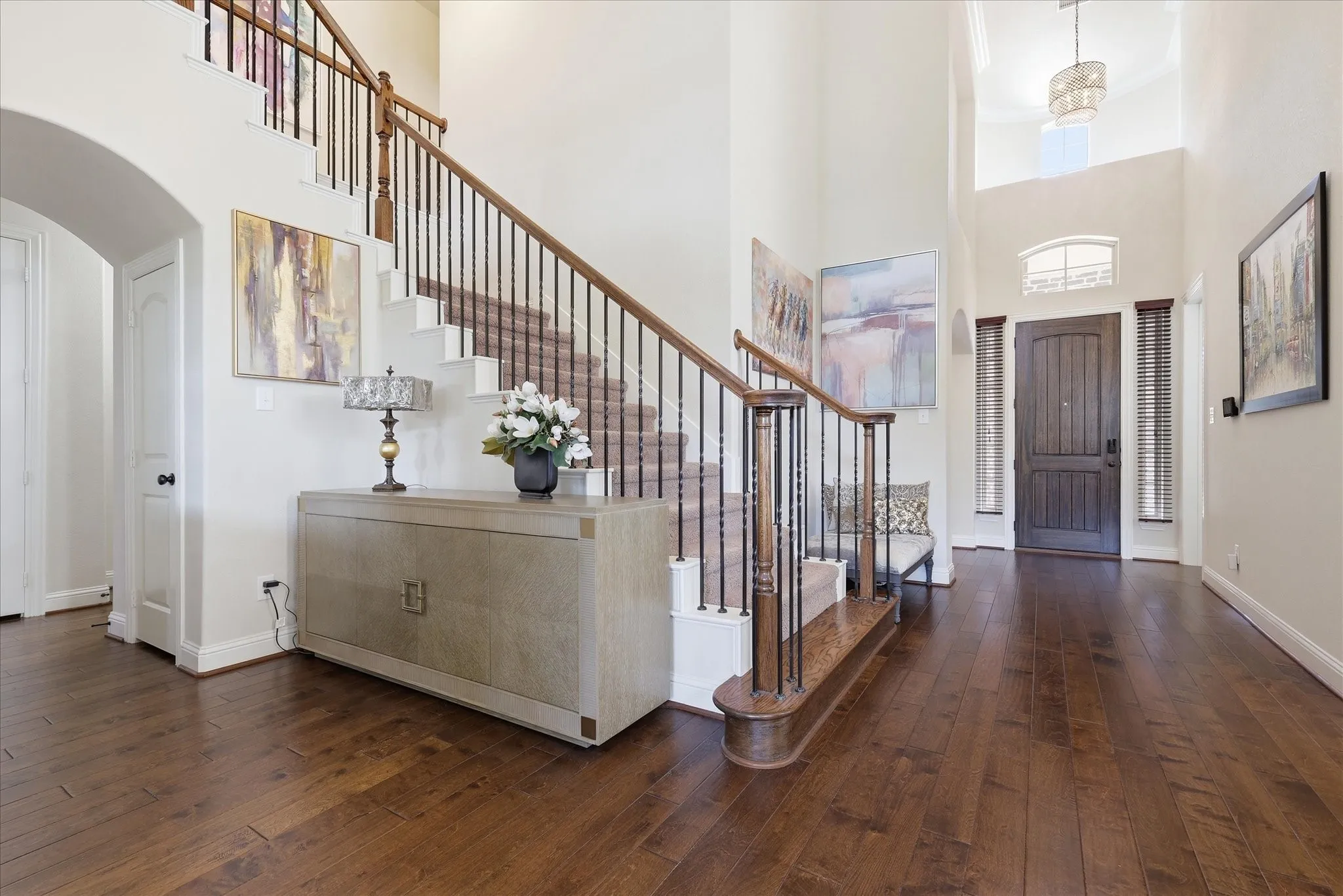 Grand, two story entry with soaring ceilings, wrought iron staircase and warm hardwood floors throughout.
