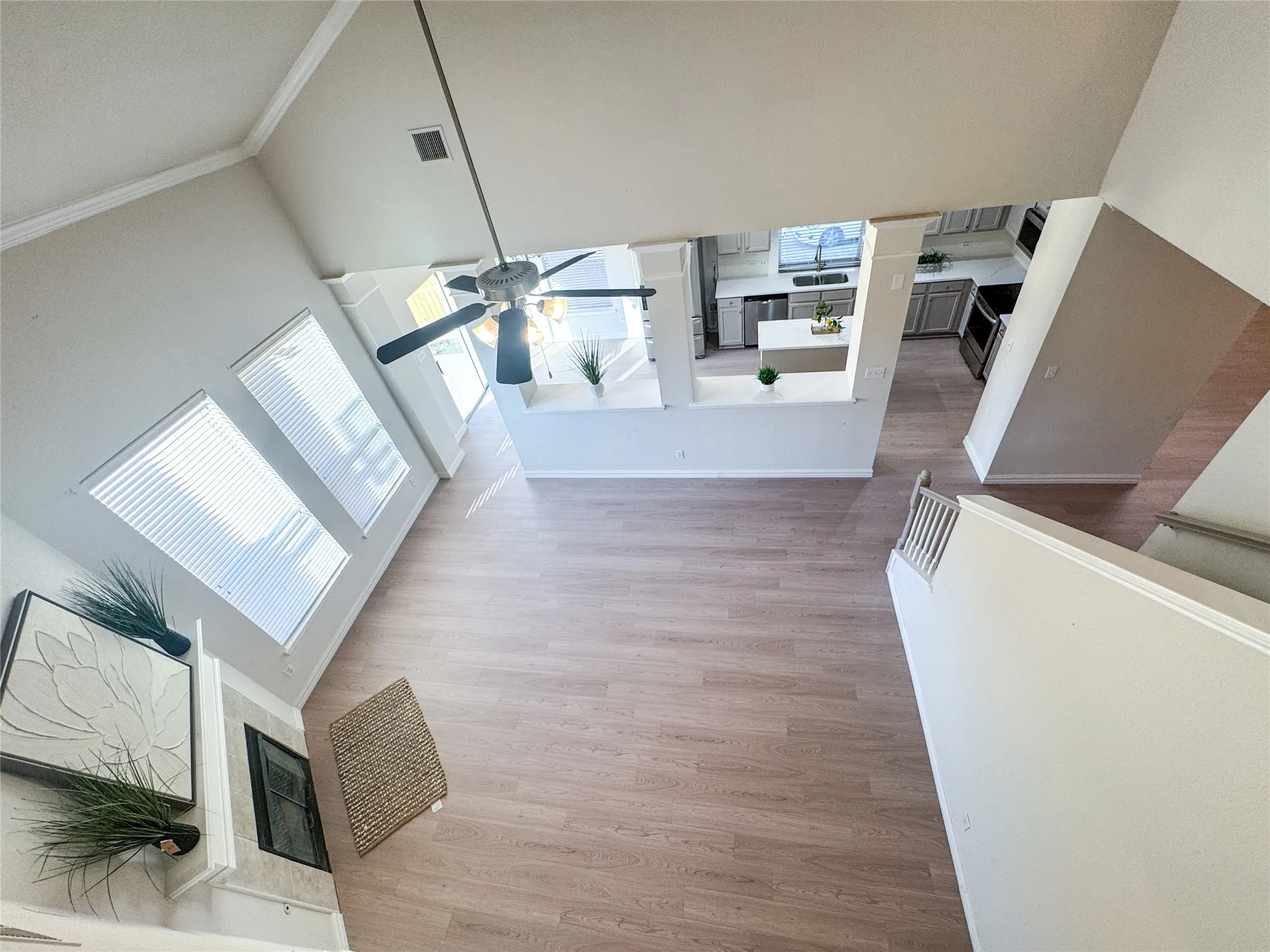 Open-concept living space featuring wood-finish flooring, a vaulted ceiling, and a ceiling fan