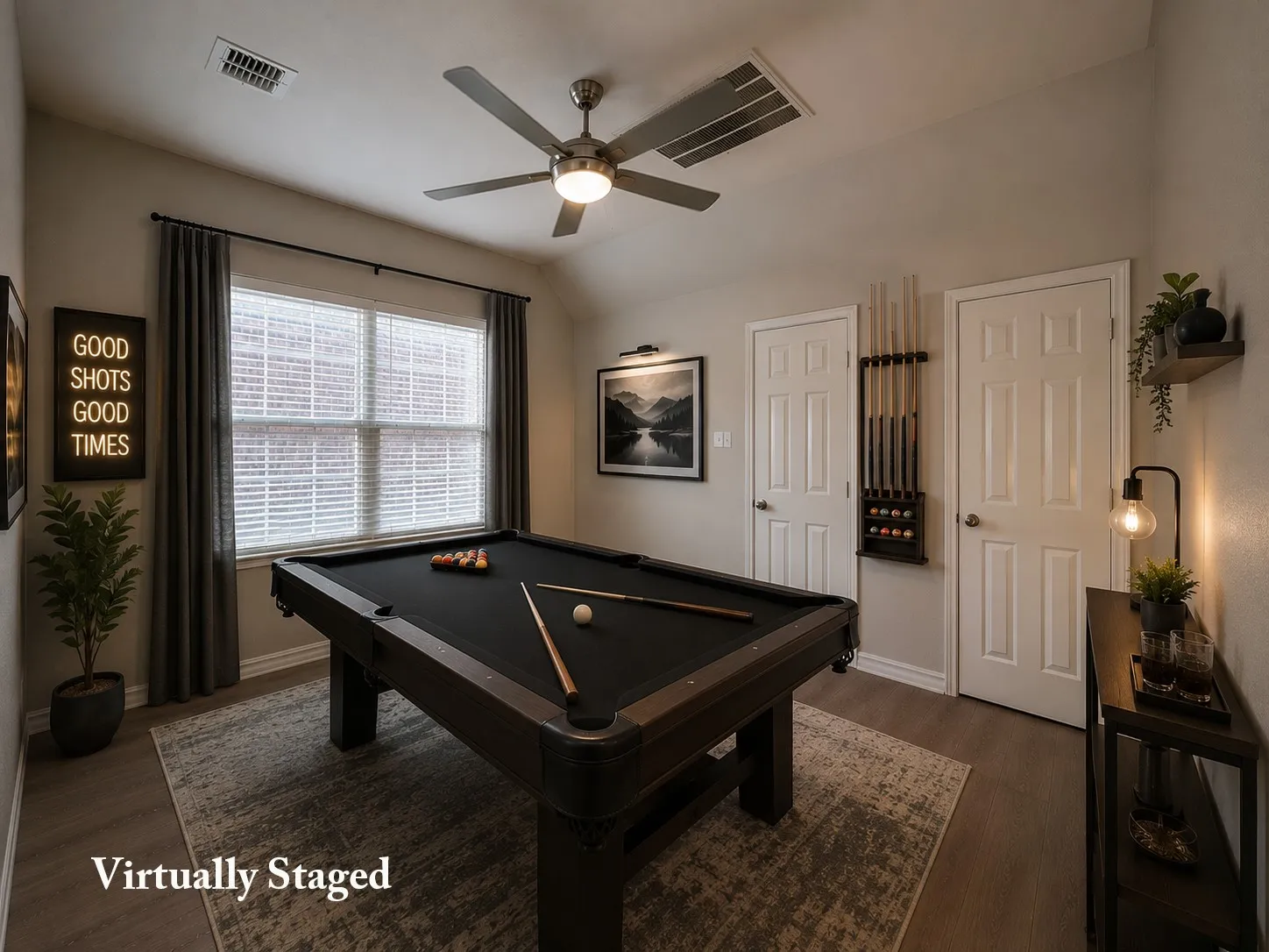 Spacious room featuring wood-finish flooring, a ceiling fan with integrated lighting, and a large window with blinds and drapes