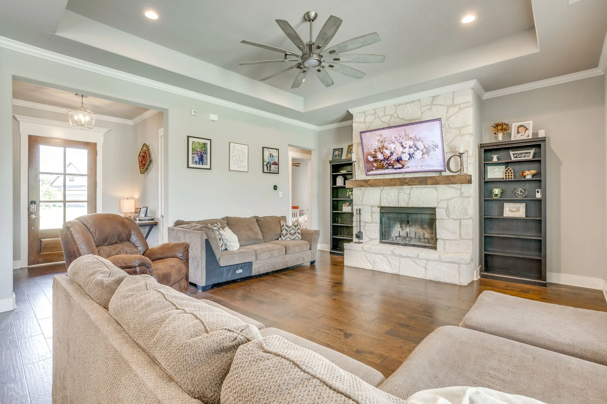 Spacious living area featuring a stone-clad fireplace with a wood mantel
