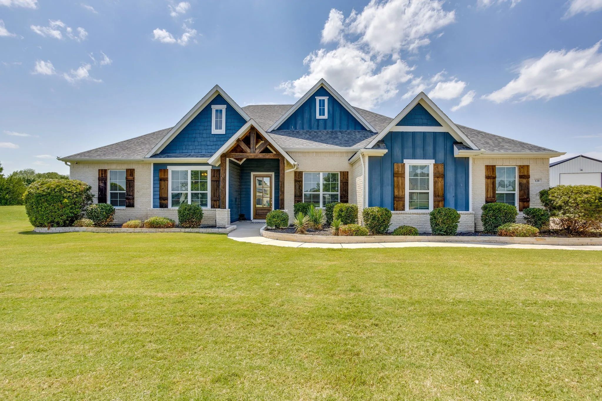 Exterior with stone facade, light blue vertical siding