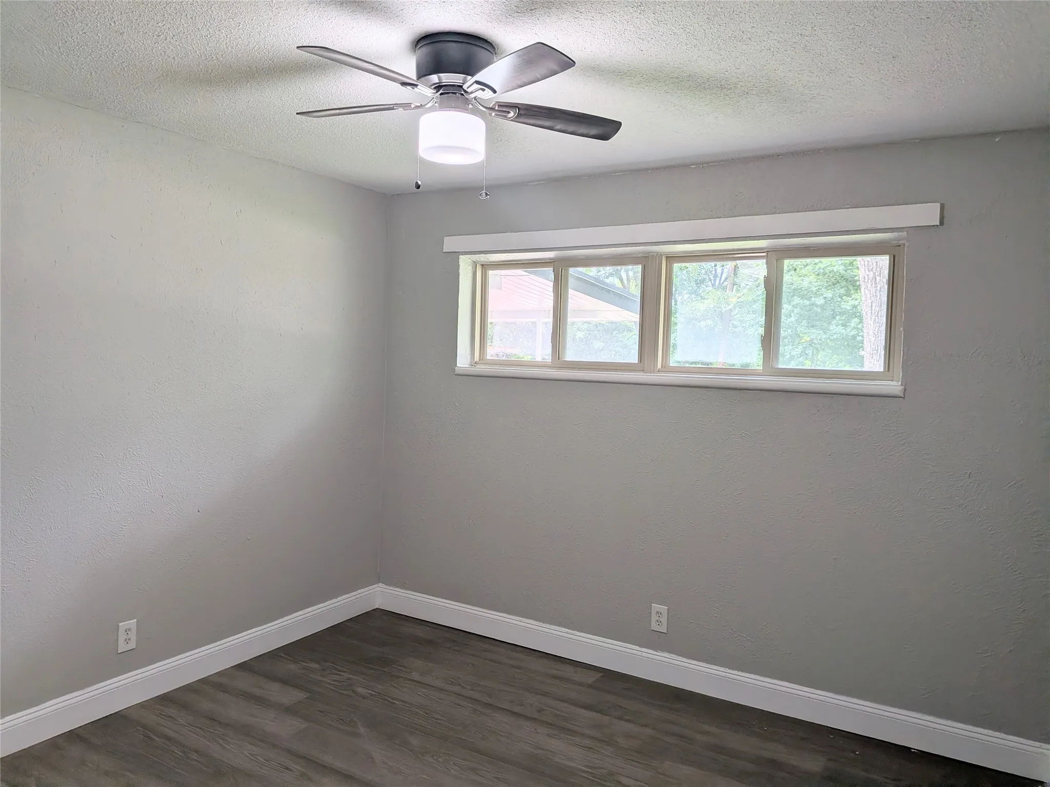 Interior space featuring wood-finish flooring, light gray walls, and white baseboards