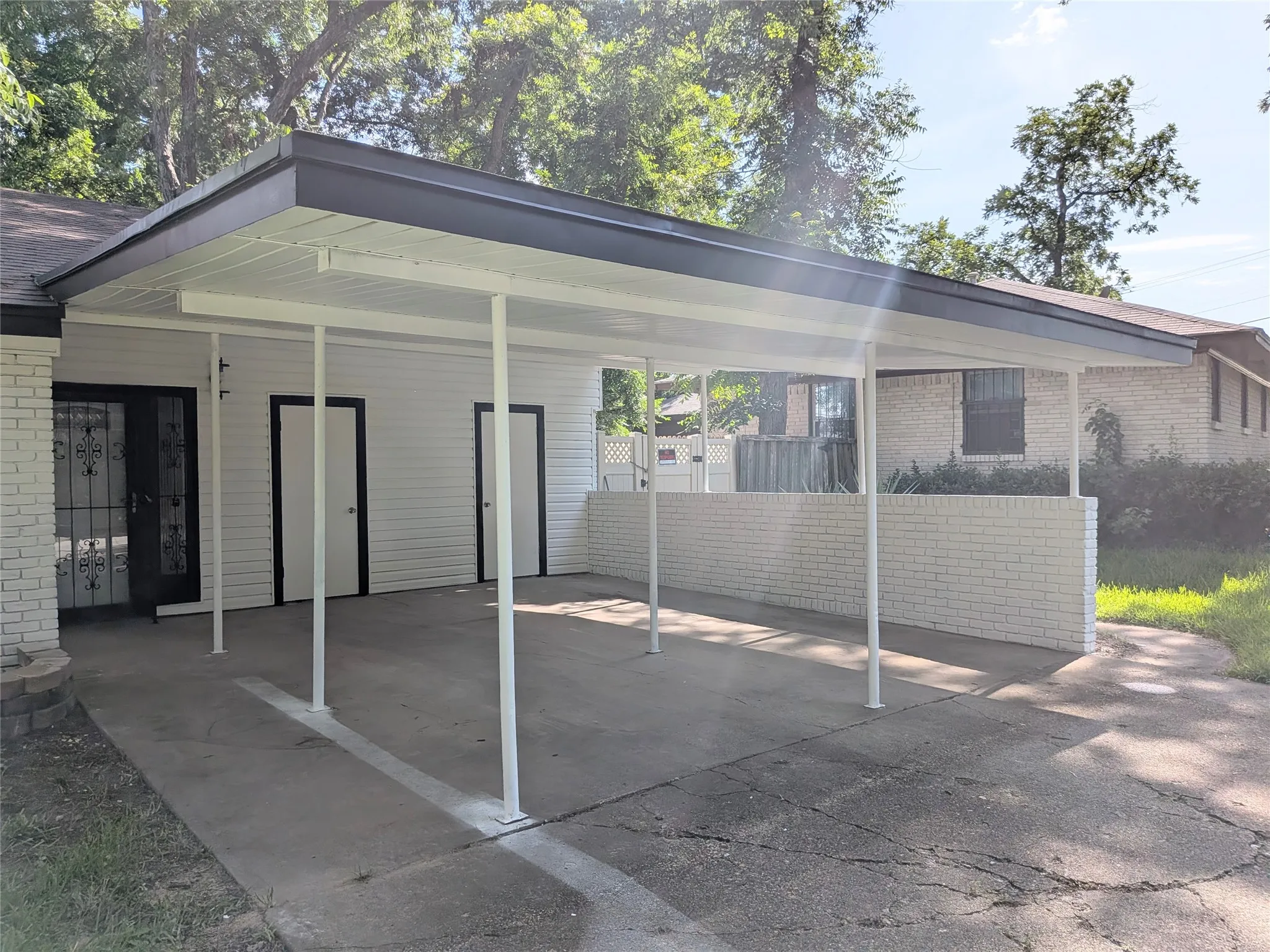 Covered carport with white support columns