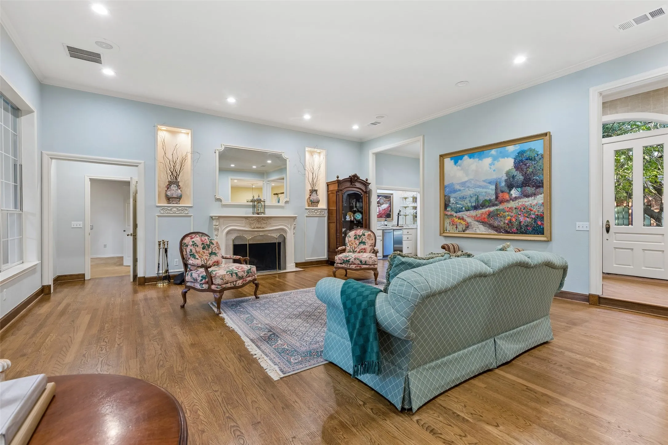 Gleaming hardwoods, high ceiling and custom fireplace greet you.  Decorative lighted Art displays on both sides of the Fireplace.