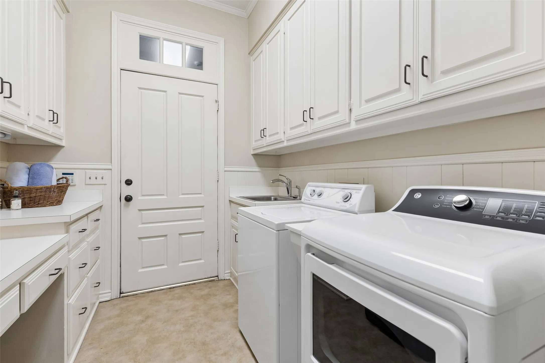 Cabinets line both walls of laundry room PLUS drawer and desk area.  Sink and refrigerator, too!  Appliances stay with the property for the new owners.