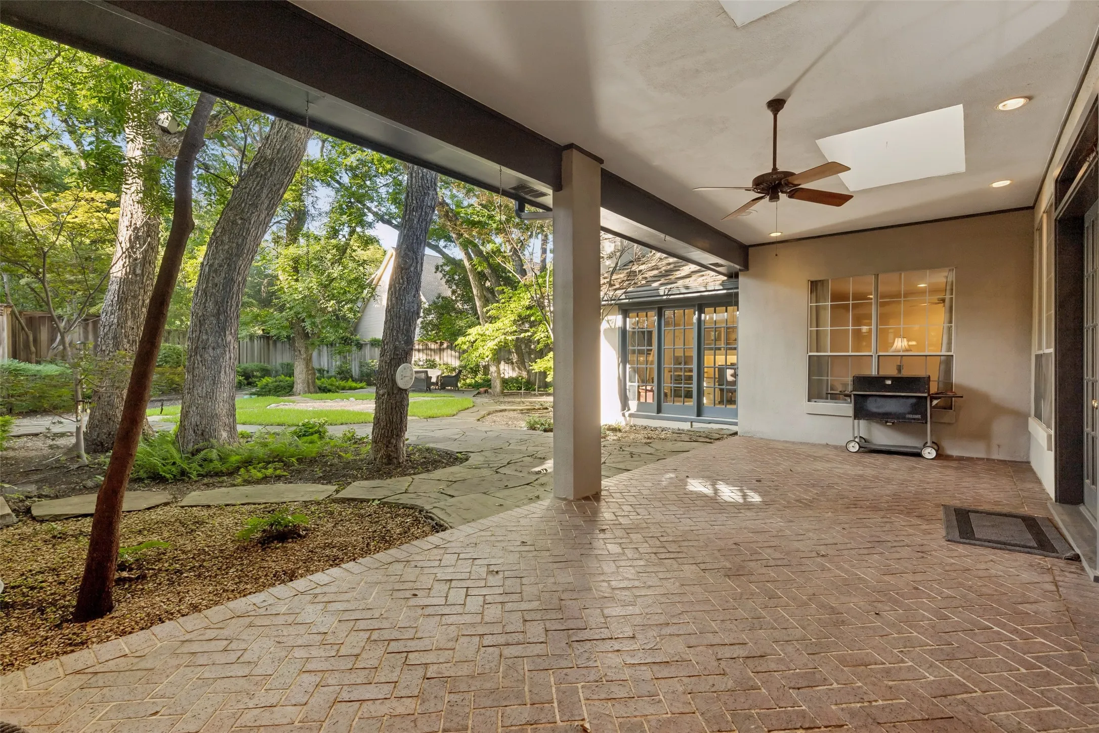 Huge Patio features 2 Skylights with scenic view of lush backyard