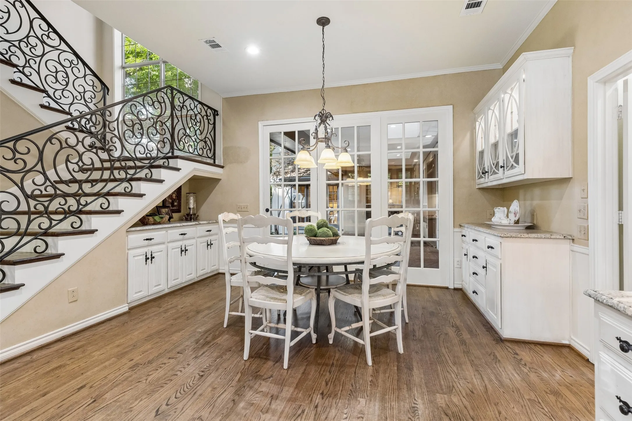 Breakfast Room is flanked with cabinets galore, and a view to the outdoors!  French Doors provide easy access to the patio or barbeque area.  Hardwood flooring, elegant lighting and lots of space for storage of dishes, platters, etc.