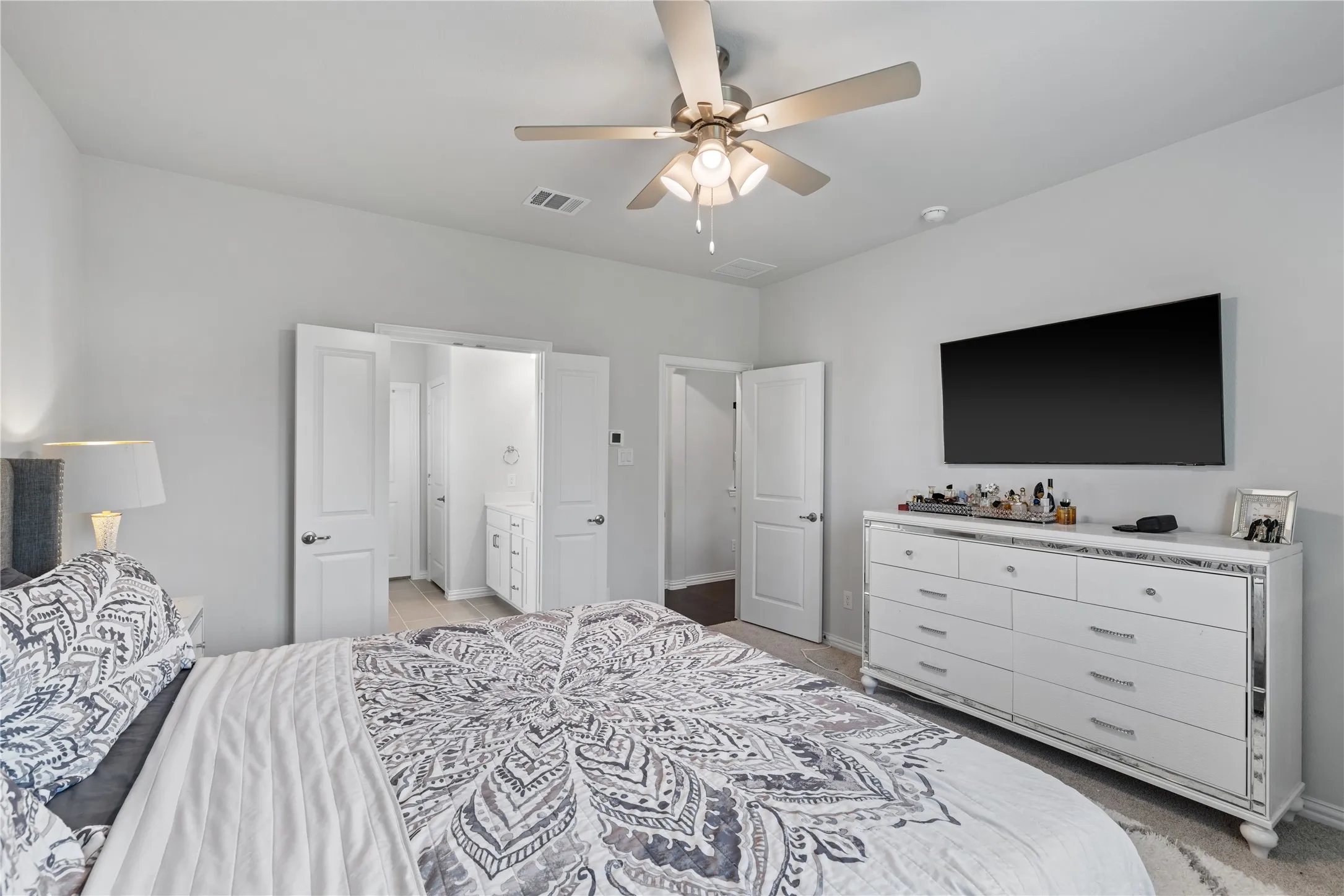 Spacious primary suite with private ensuite bath, large walk-in closet, abundant natural light, and thoughtful separation from secondary bedrooms for added privacy.
