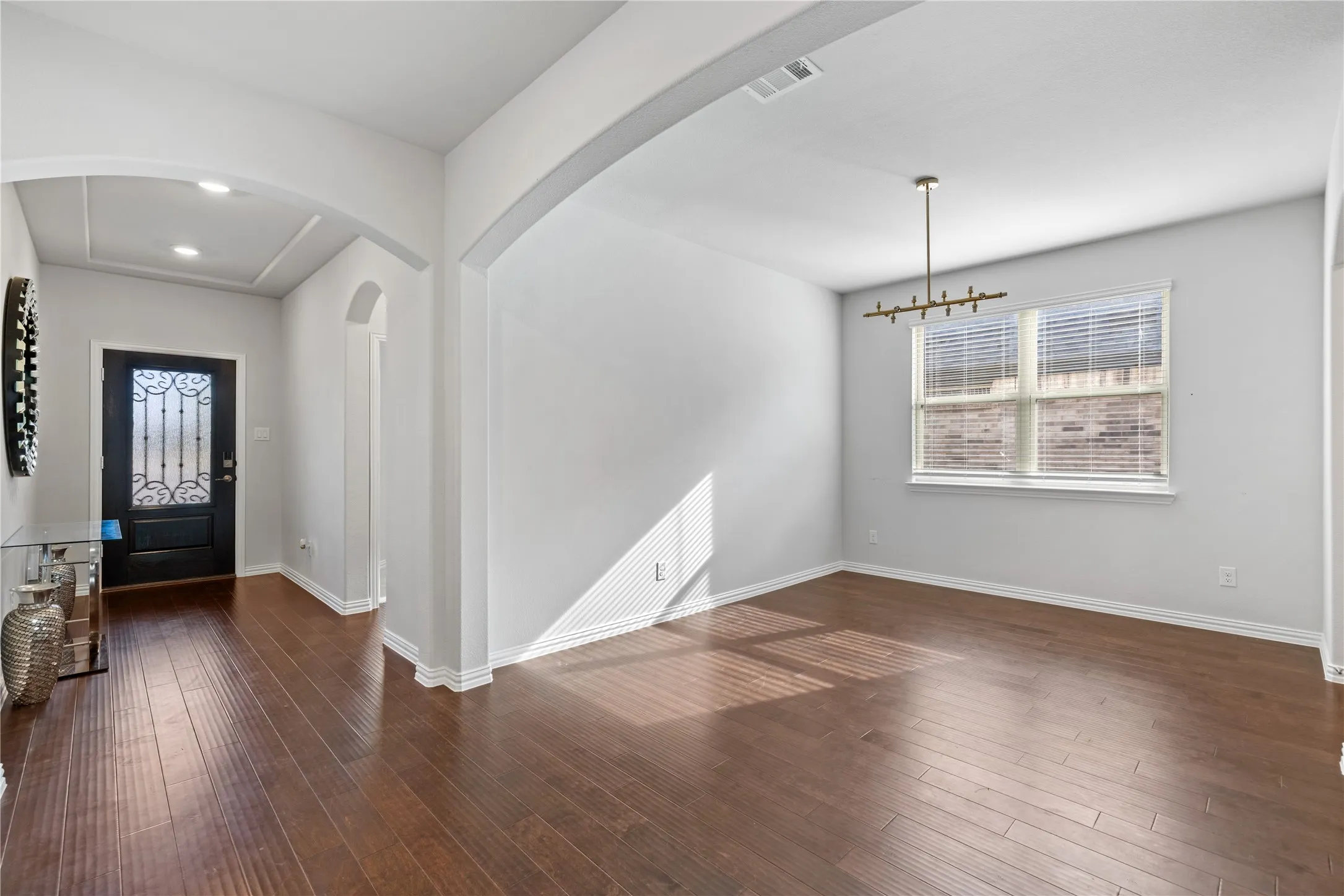Entrance foyer. Spacious formal dining room with hardwood flooring, designer lighting, oversized windows, and flexible space for entertaining, holiday gatherings, or a second living area.