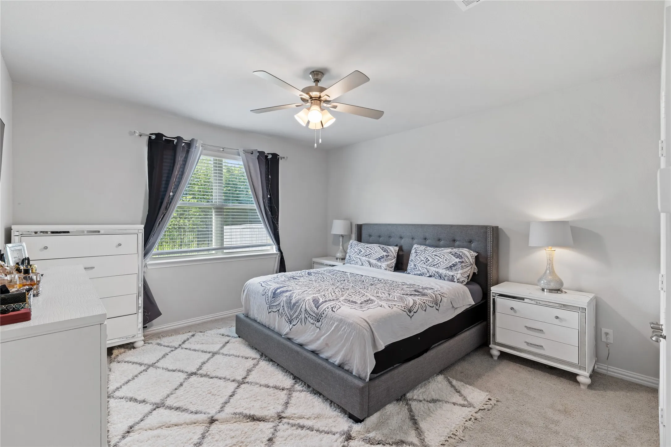 Private owner’s retreat featuring generous square footage, plush carpeting, oversized windows, tray ceiling, and ample space for a king-size bedroom set, creating the perfect place to unwind.